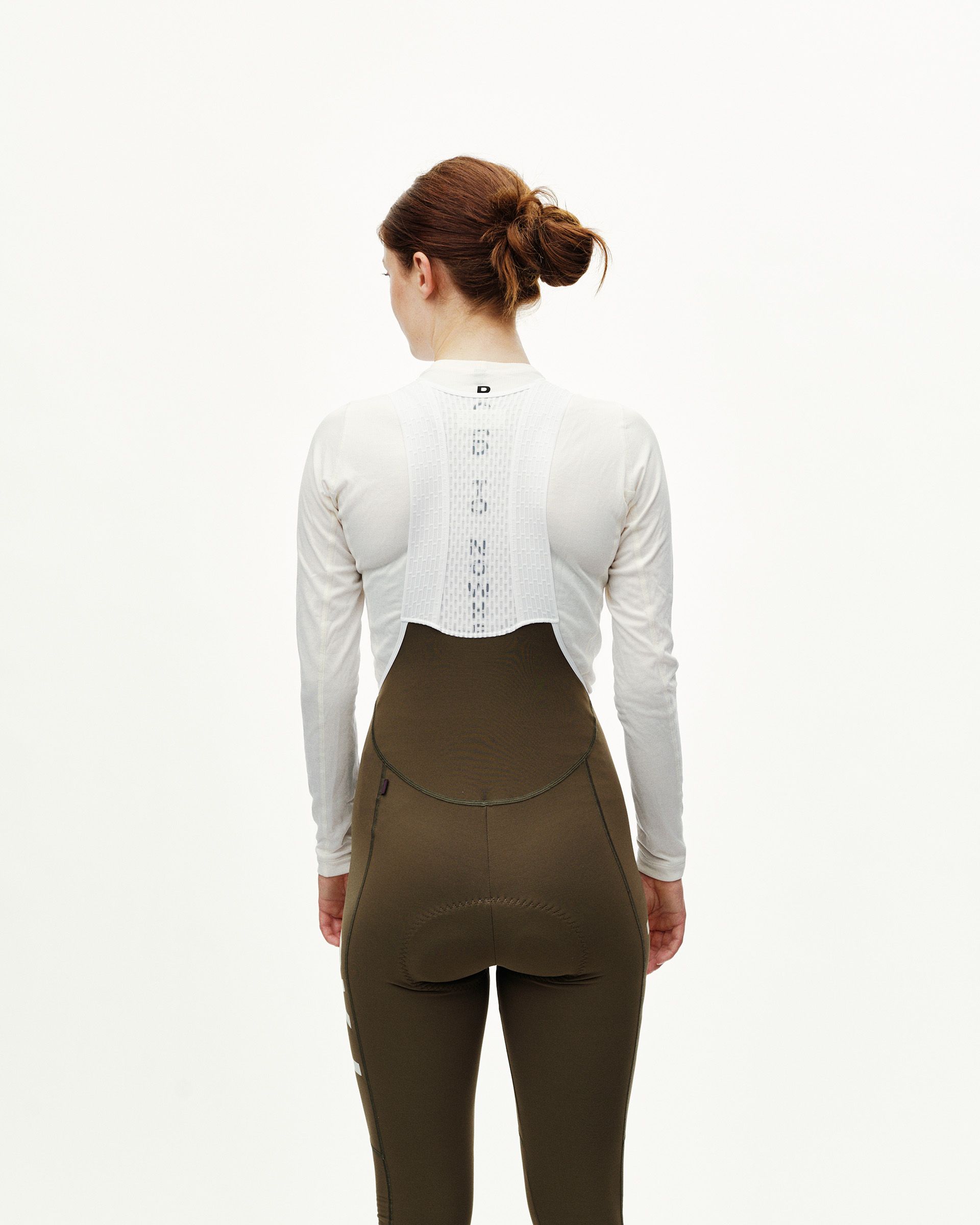 Dark Earth khaki Mechanism cycling long bibs on model, rear view with curved bib panel