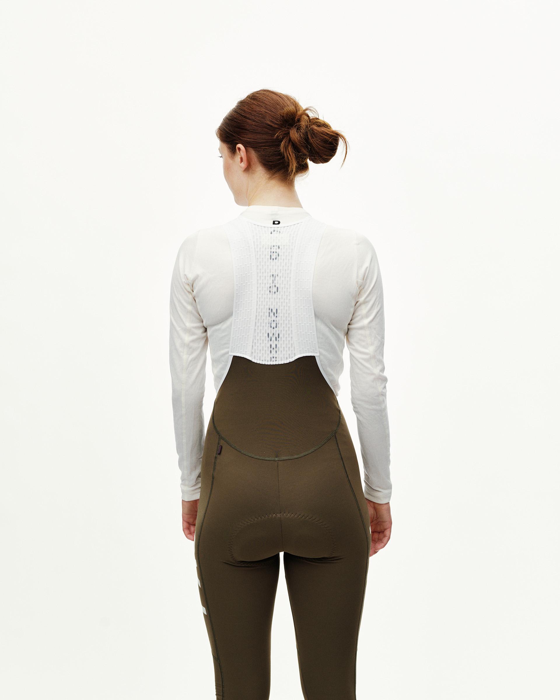 Dark Earth khaki Mechanism cycling long bibs on model, rear view with curved bib panel
