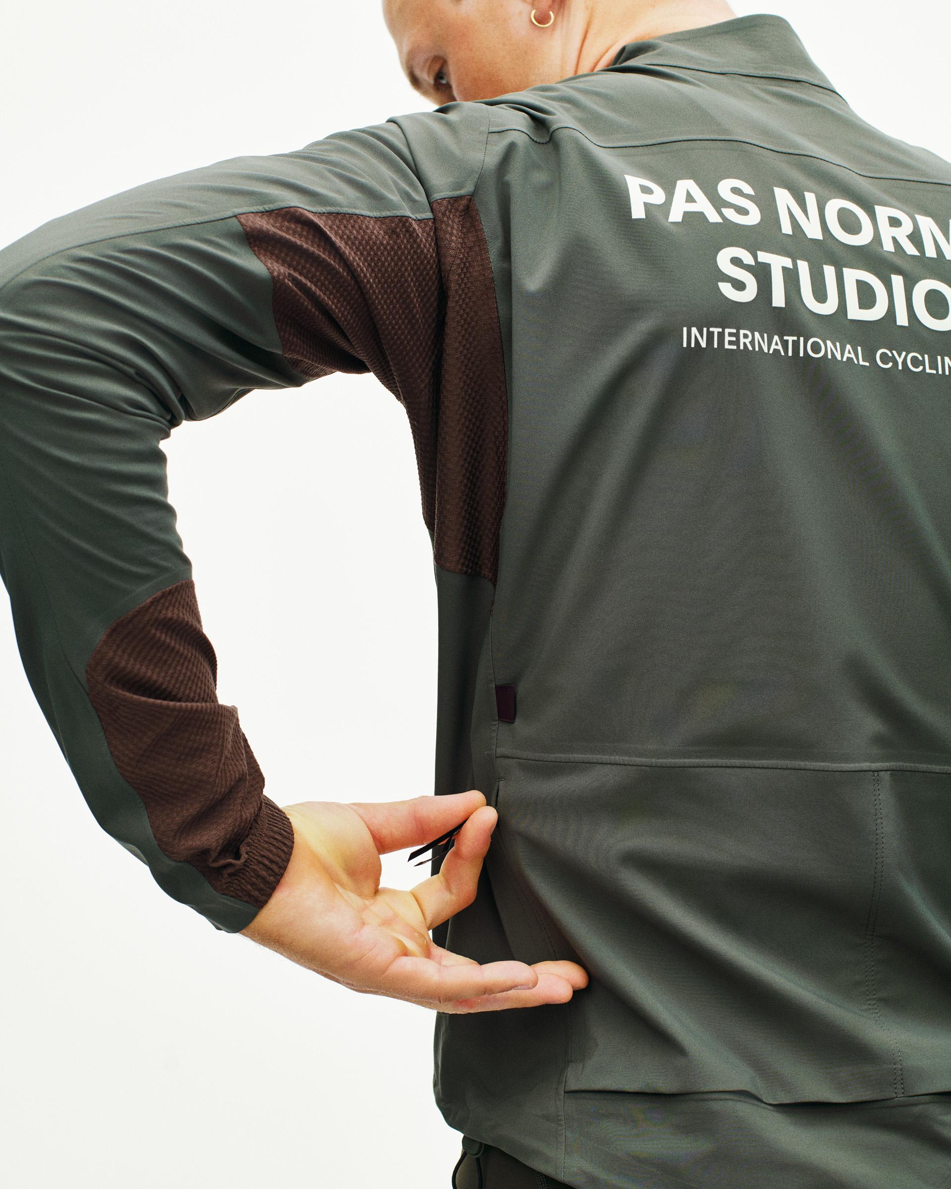 Dark Grey Mechanism Shell cycling jacket on model, rear view with white back print and rear pocket