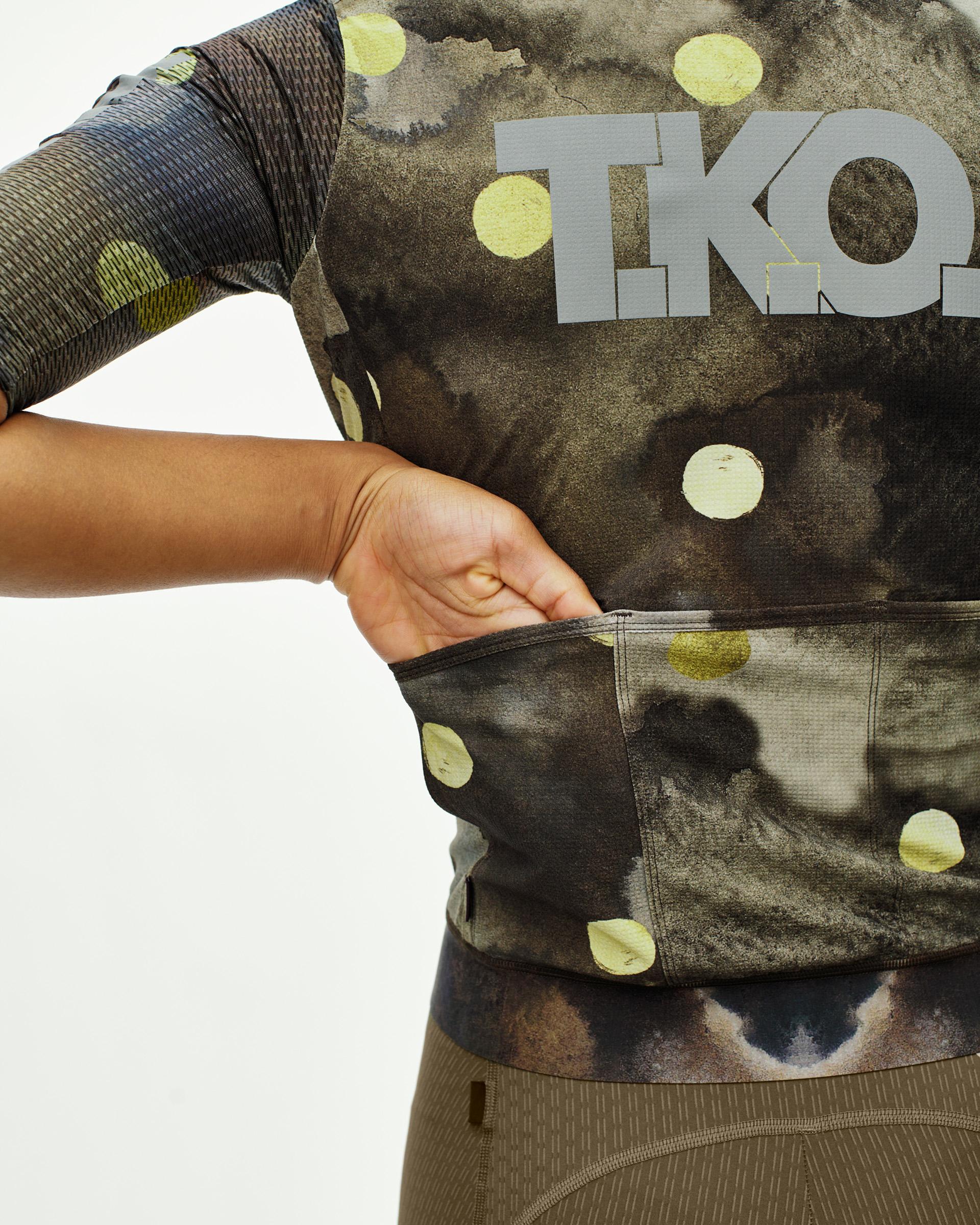 Moss Green T.K.O. Essential Light cycling jersey on model with yellow dot print and T.K.O. chest logo