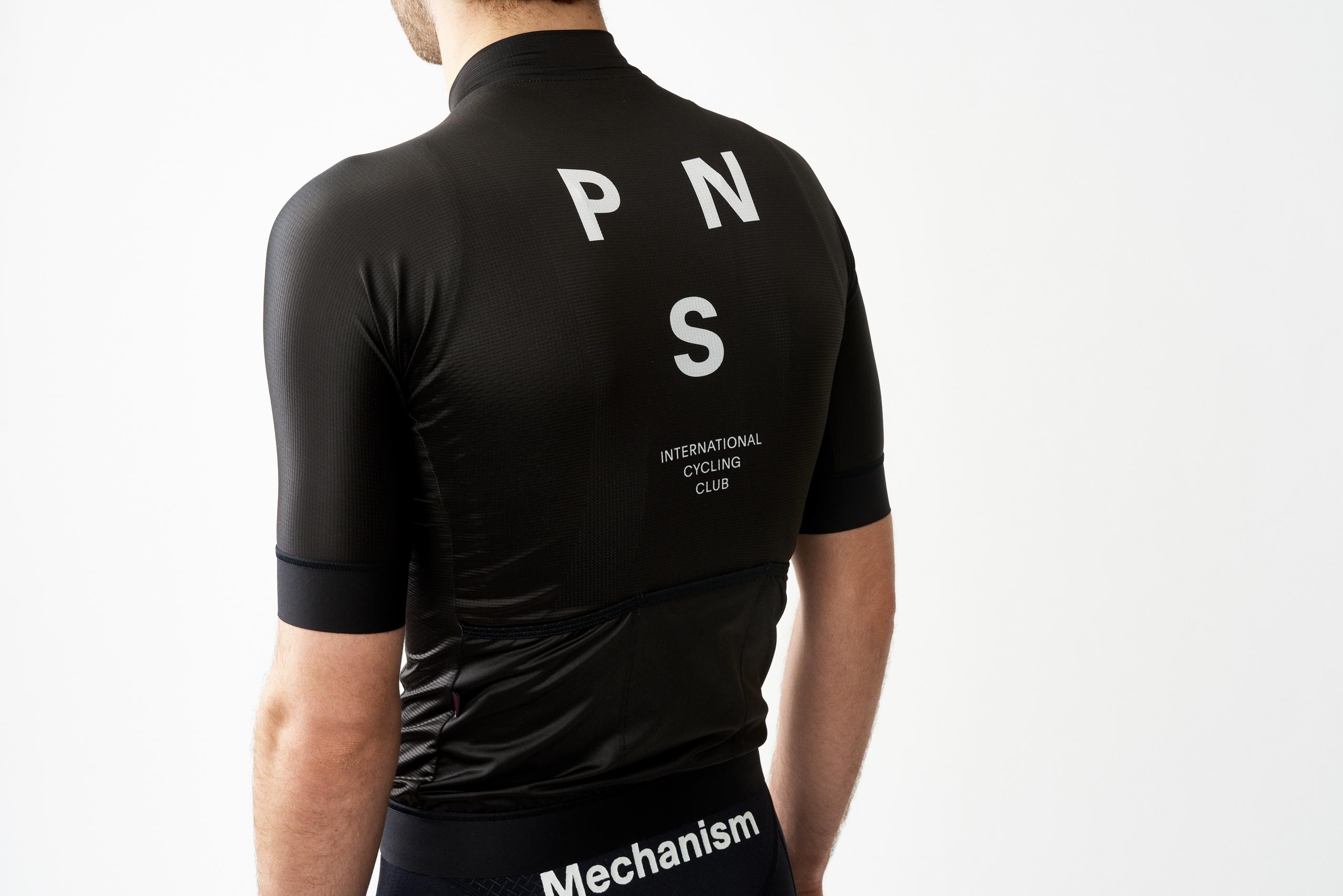 Black Mechanism cycling jersey, rear view on model with white PNS lettering and International Cycling Club text