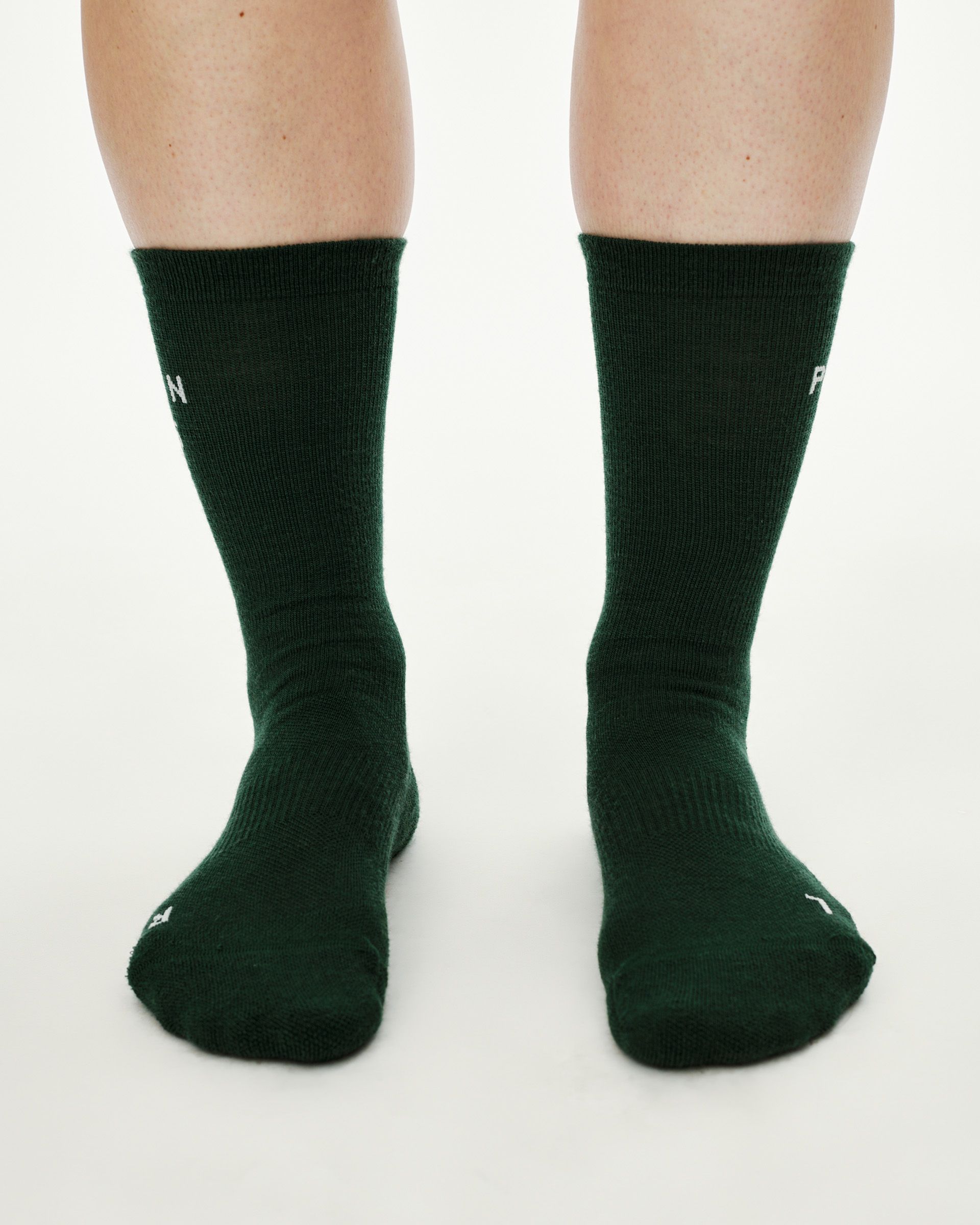 Petroleum green Essential Thermal Wool cycling socks, front view on model showing crew height and white logo text
