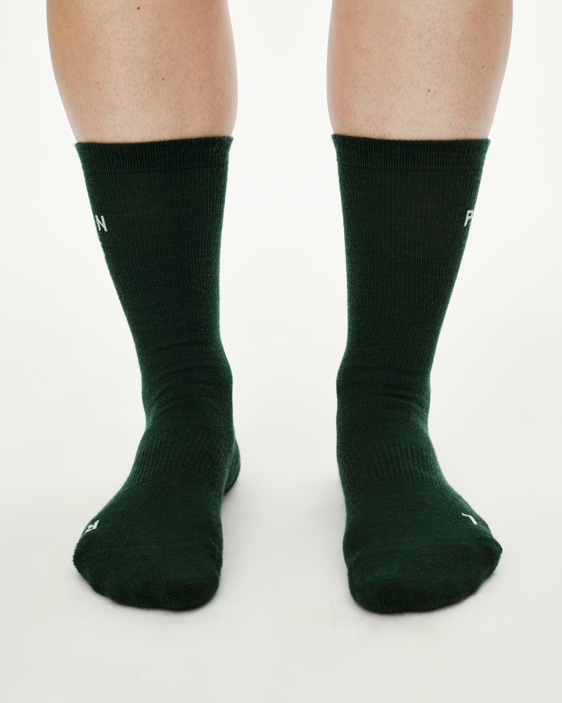 Petroleum green Essential Thermal Wool cycling socks, front view on model showing crew height and white logo text