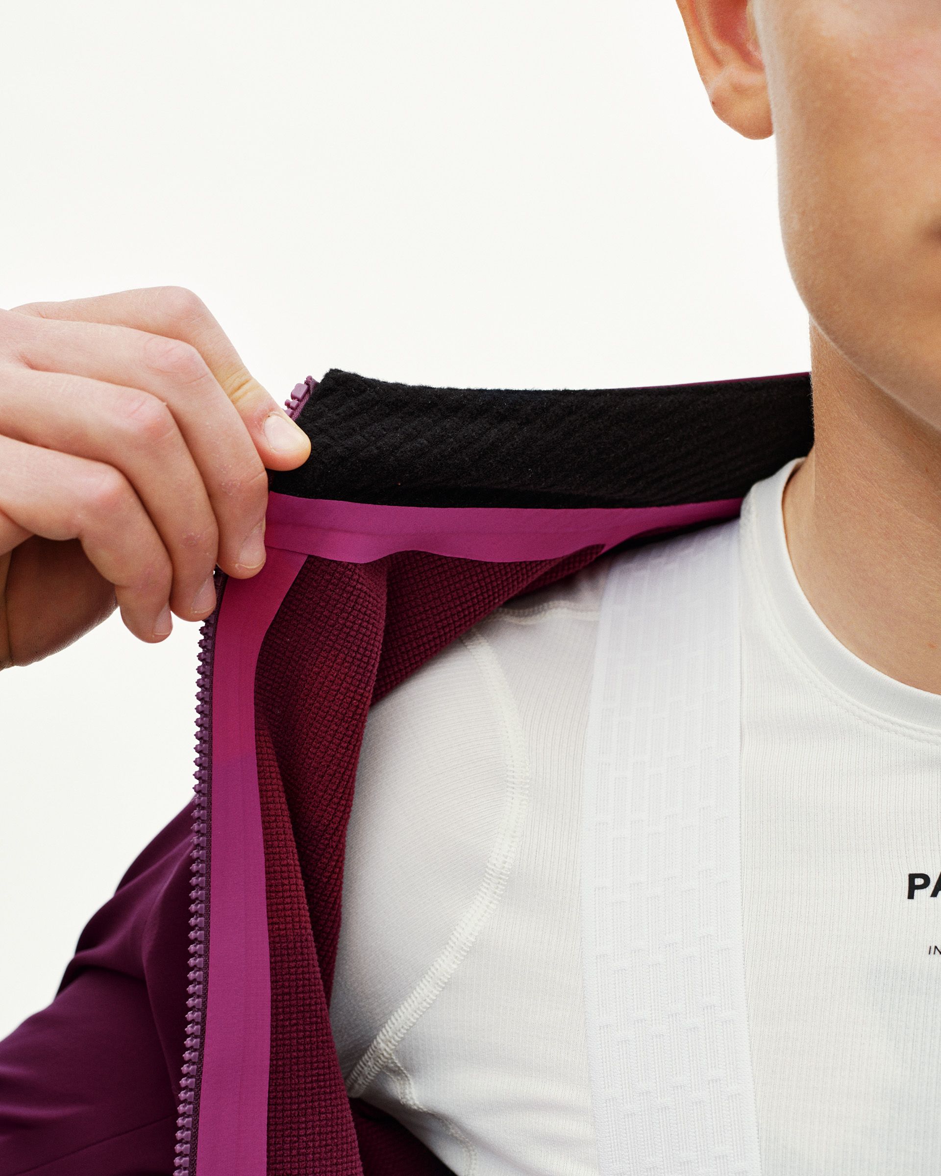 Dark Purple PAS Mechanism cycling jacket, collar detail on model showing fleece inner lining and zip guard