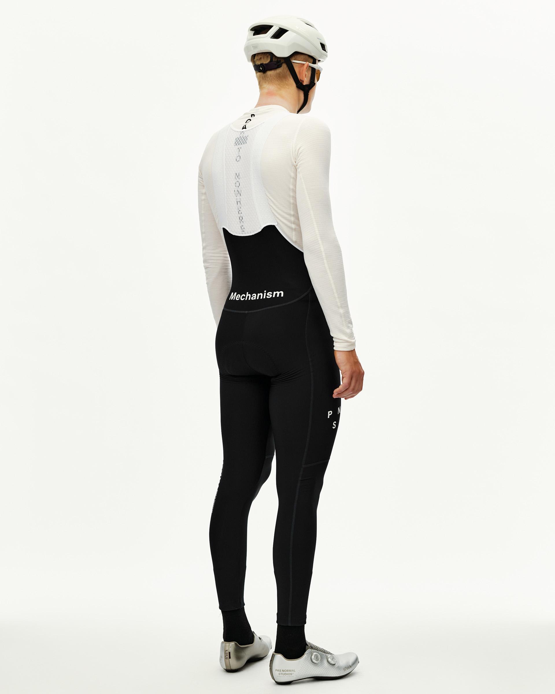 Black Mechanism Thermal Long cycling bibs on model, rear view with white bib strap panel and logo waistband