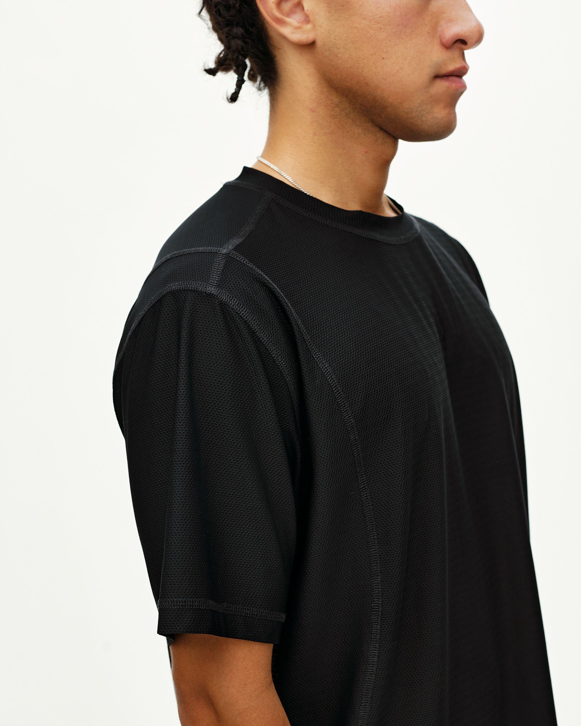Black Balance T-shirt on model, side view with contrast stitching and mixed mesh panels