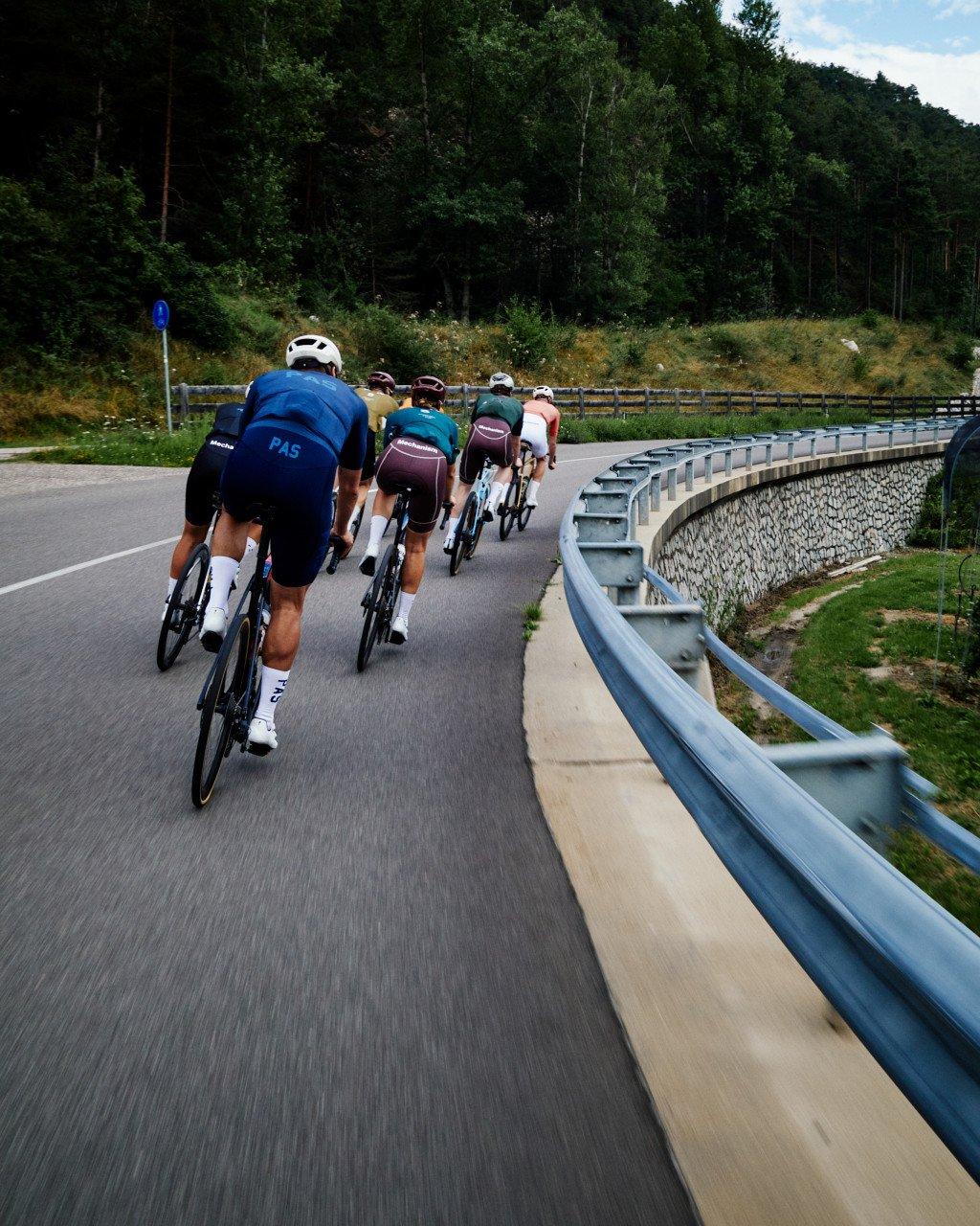 Cyclists in PAS collection jerseys riding in formation on mountain road