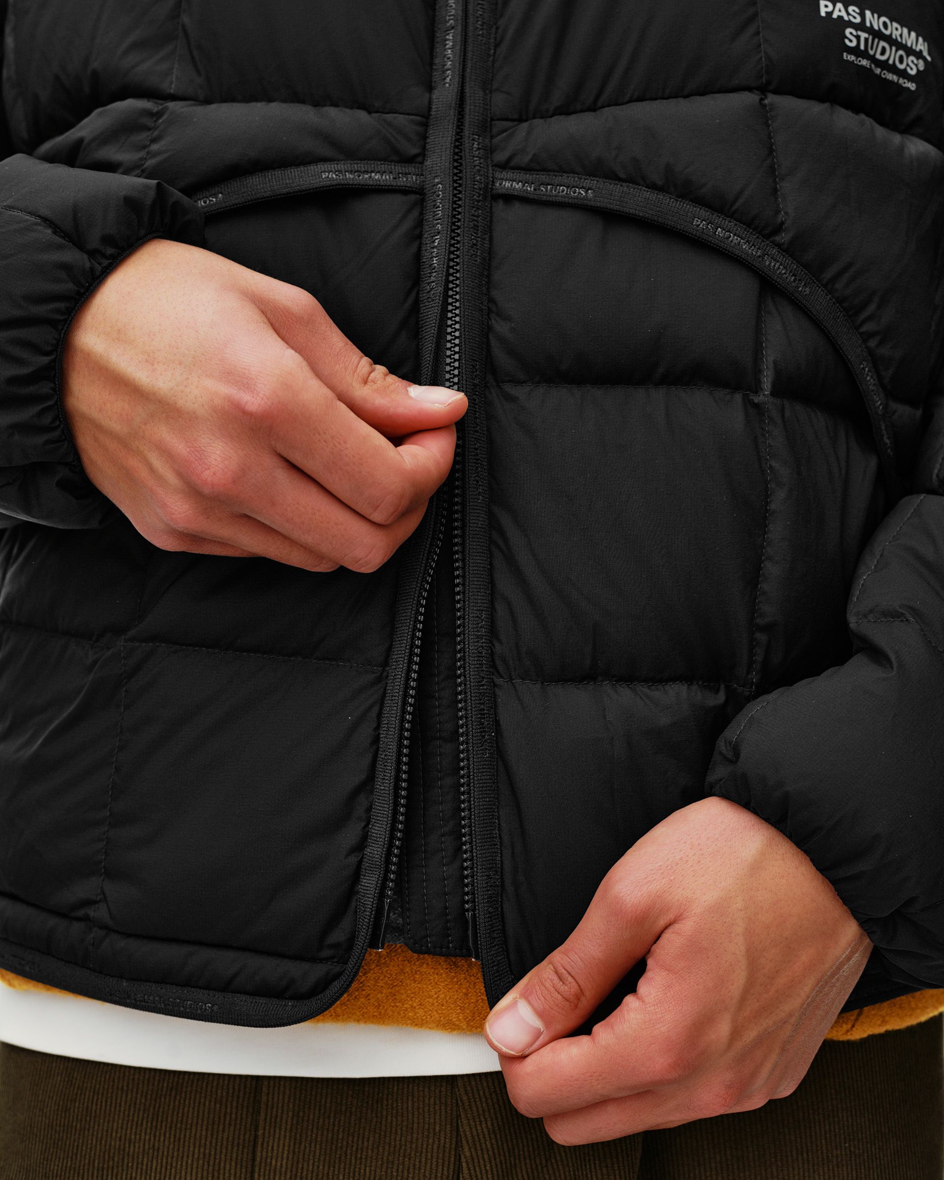 Black Off-Race Down Liner jacket, detail view on model showing open front zip and quilted panels