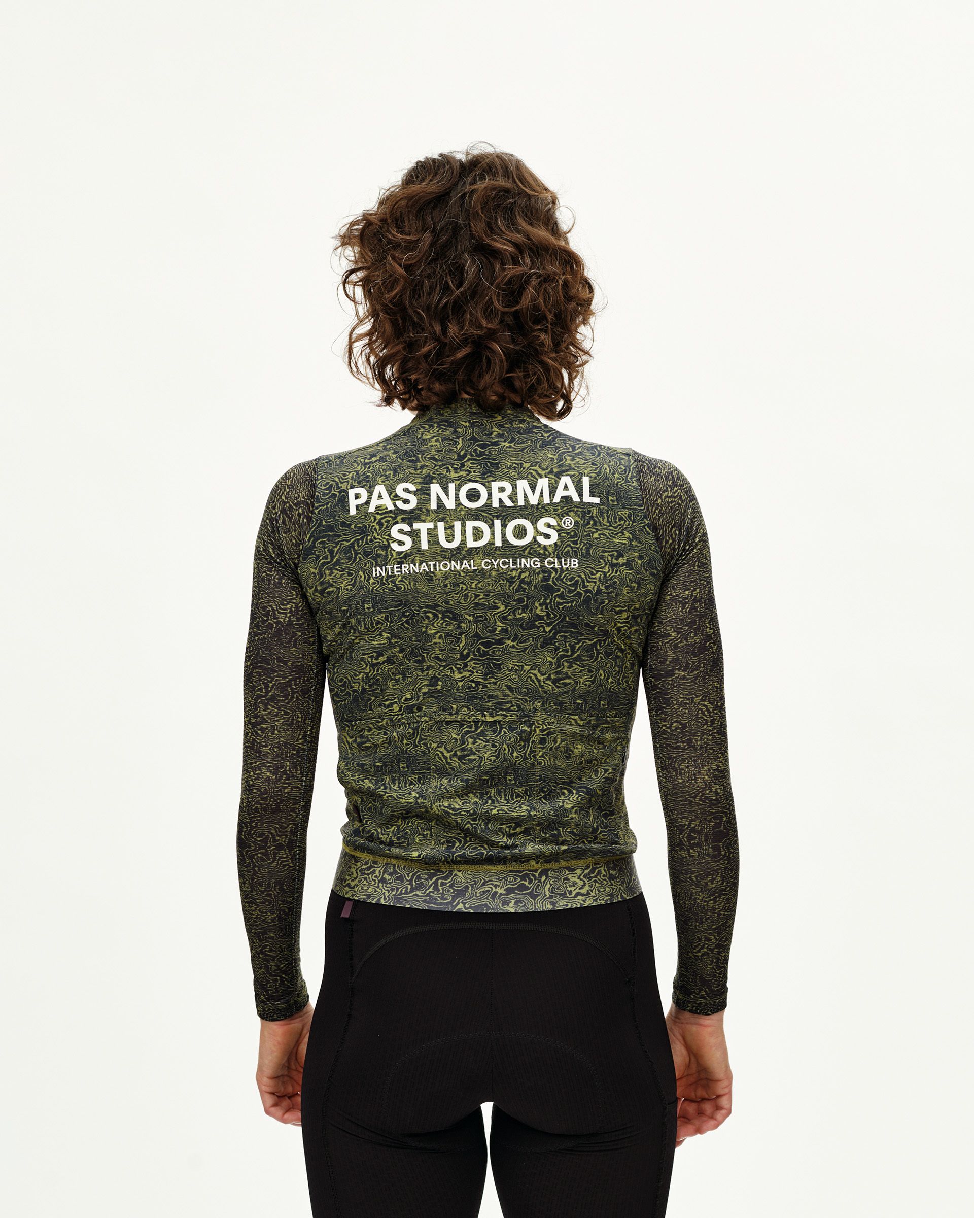 Dark Lime Essential cycling jersey on model, rear view with allover abstract print and white back logo