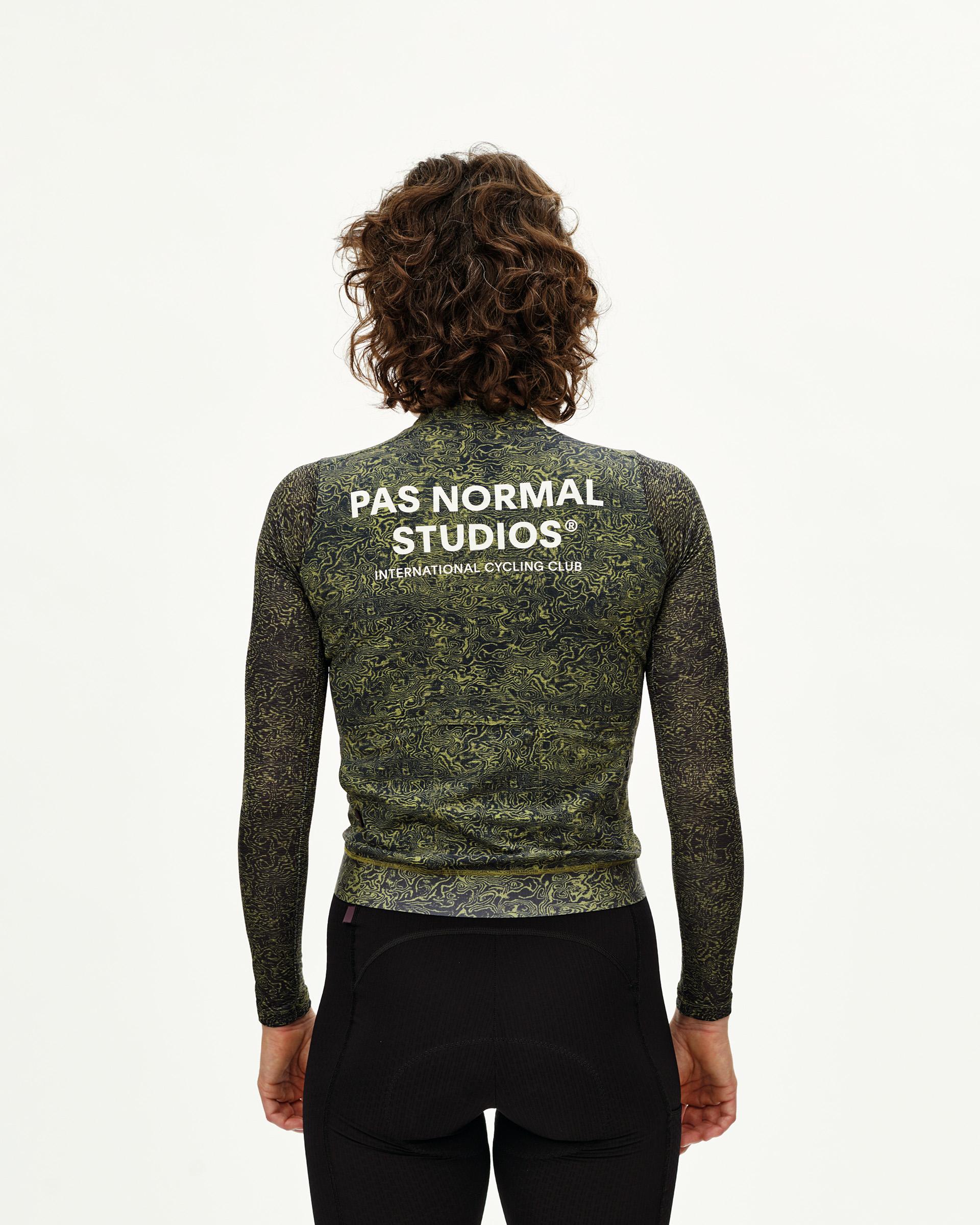 Dark Lime Essential cycling jersey on model, rear view with allover abstract print and white back logo