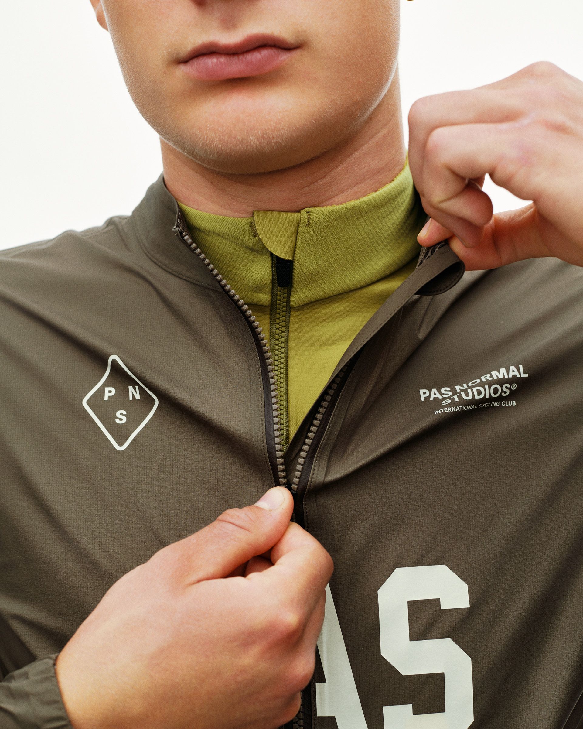 Dark Earth khaki PAS Mechanism cycling rain jacket, front detail on model with full zip and large chest logo print