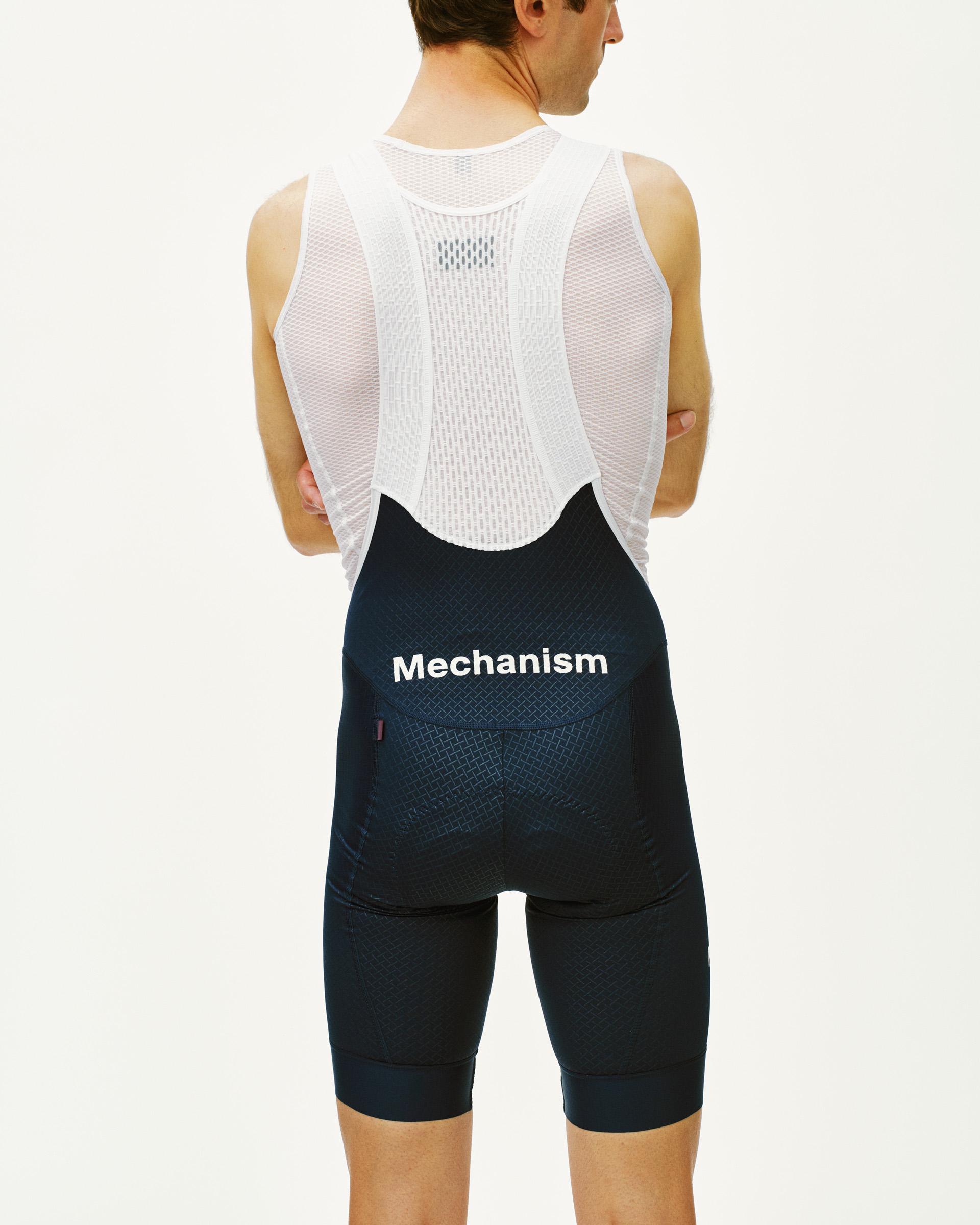 Navy Mechanism cycling bibs on model, rear view with white mesh base layer