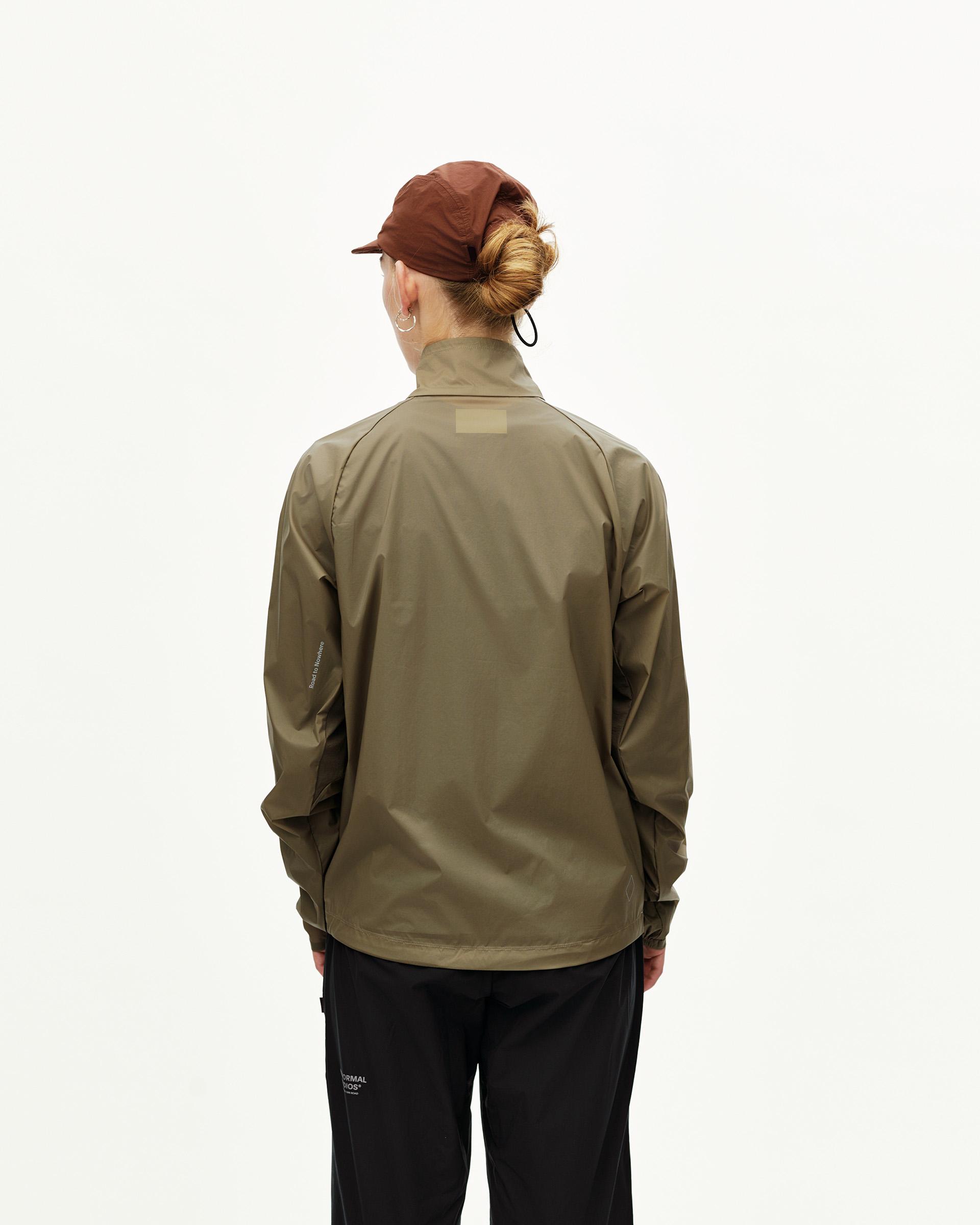 Dusty Earth khaki Balance Windproof jacket on model, rear view with tonal back patch label