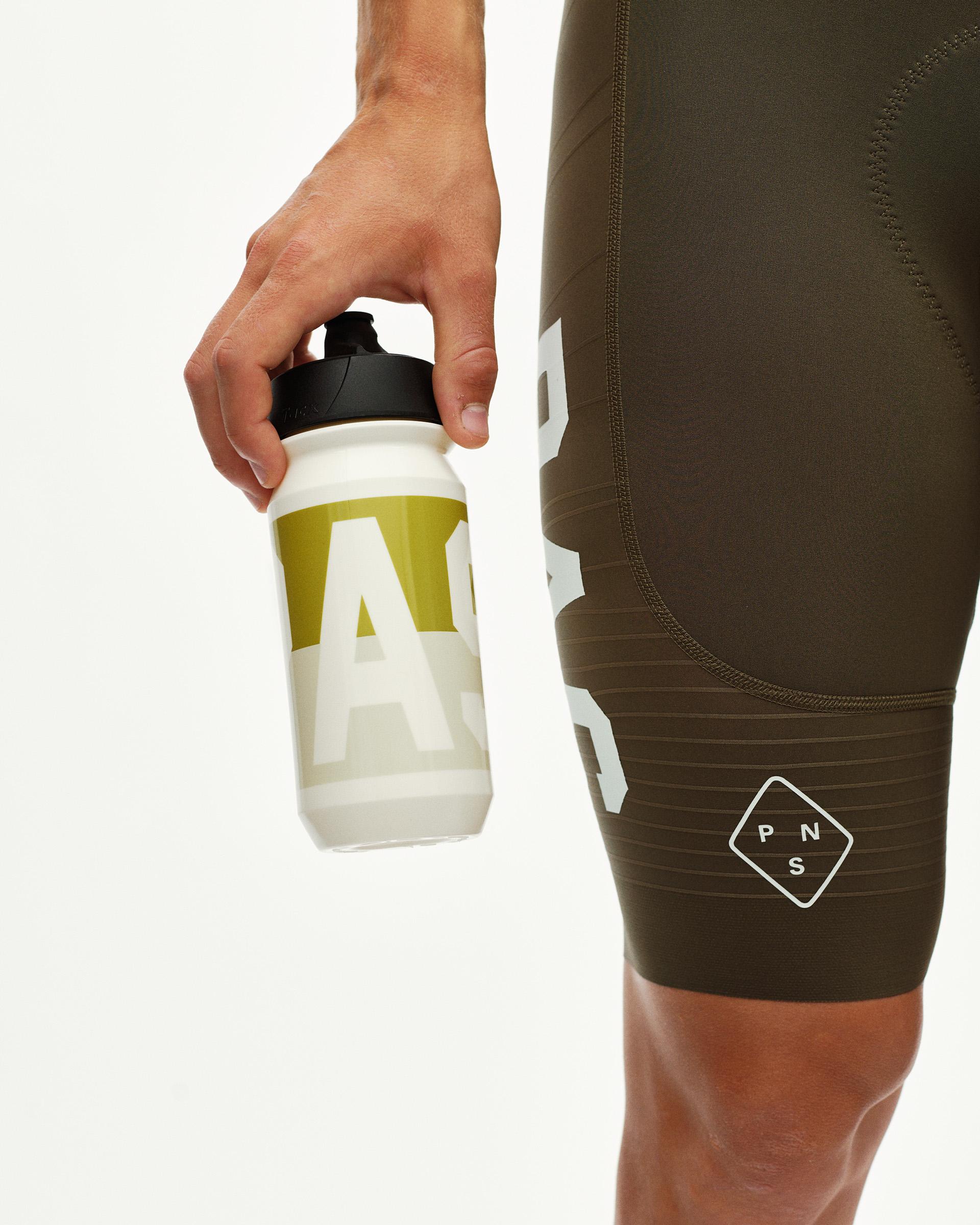 Off White PAS cycling water bottle held by model, with olive green and white large-letter graphic print