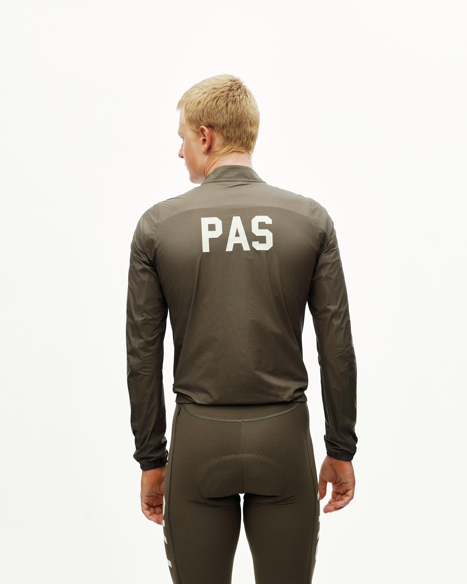 Dark Earth khaki PAS Mechanism cycling rain jacket on model, rear view with white PAS back print