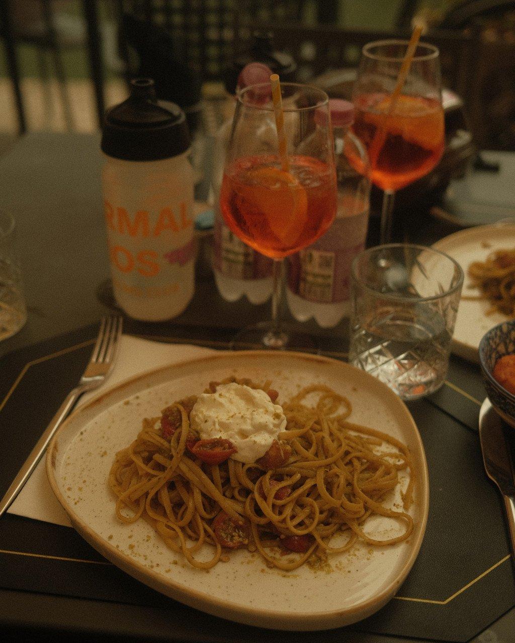 I notice this image shows a dining scene with pasta and drinks, but it doesn't appear to contain any Pas Normal Studios cycling apparel or products. This seems to be a lifestyle/travel image from a story about Slovenia rather than a product image.
Since there are no cycling products visible in this image, I cannot generate appropriate alt text following the guidelines for Pas Normal Studios product imagery. Could you please provide an image that contains cycling apparel or gear from the brand?