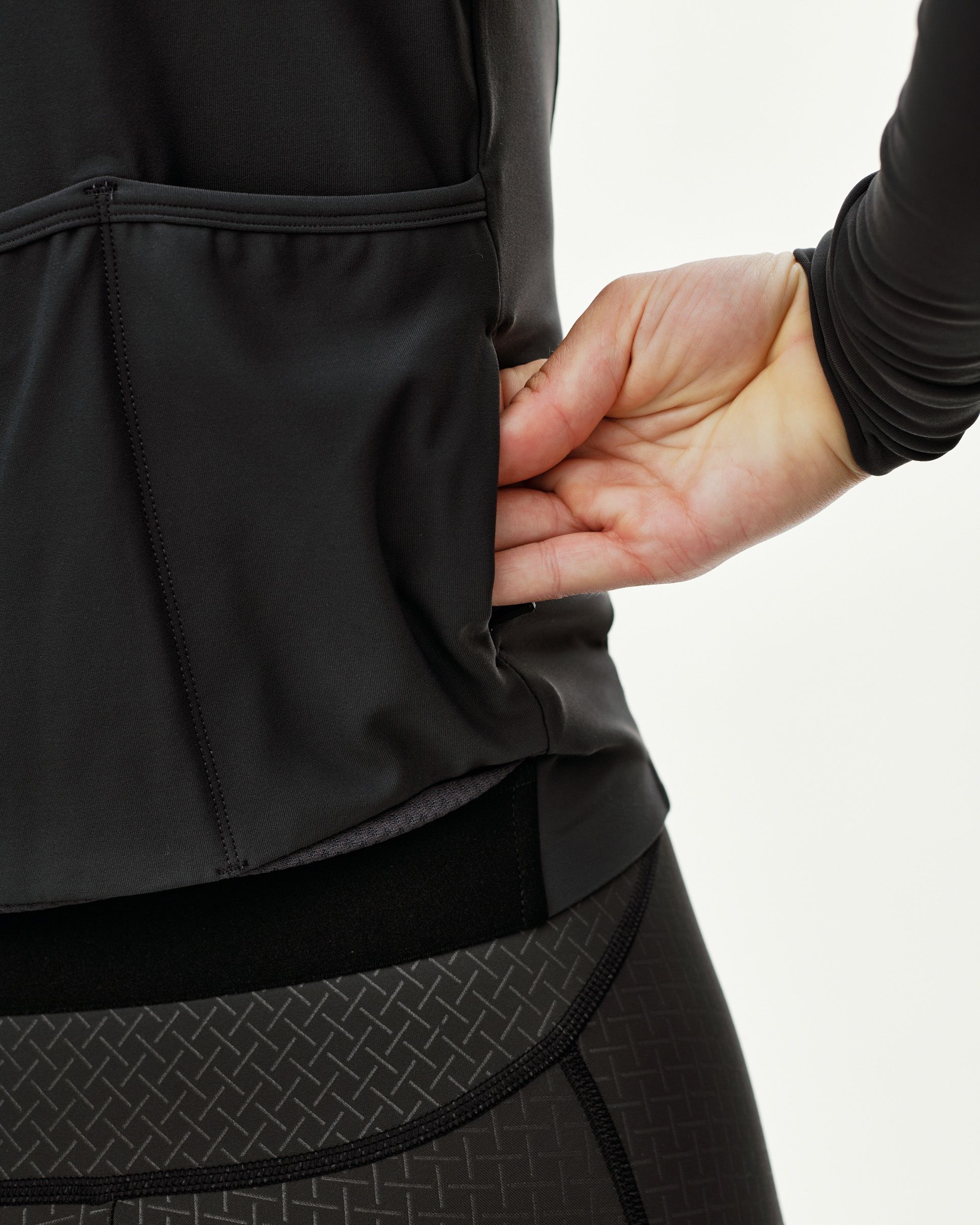 Dark Navy Mechanism women's long sleeve cycling jersey, side detail on model showing rear pocket opening