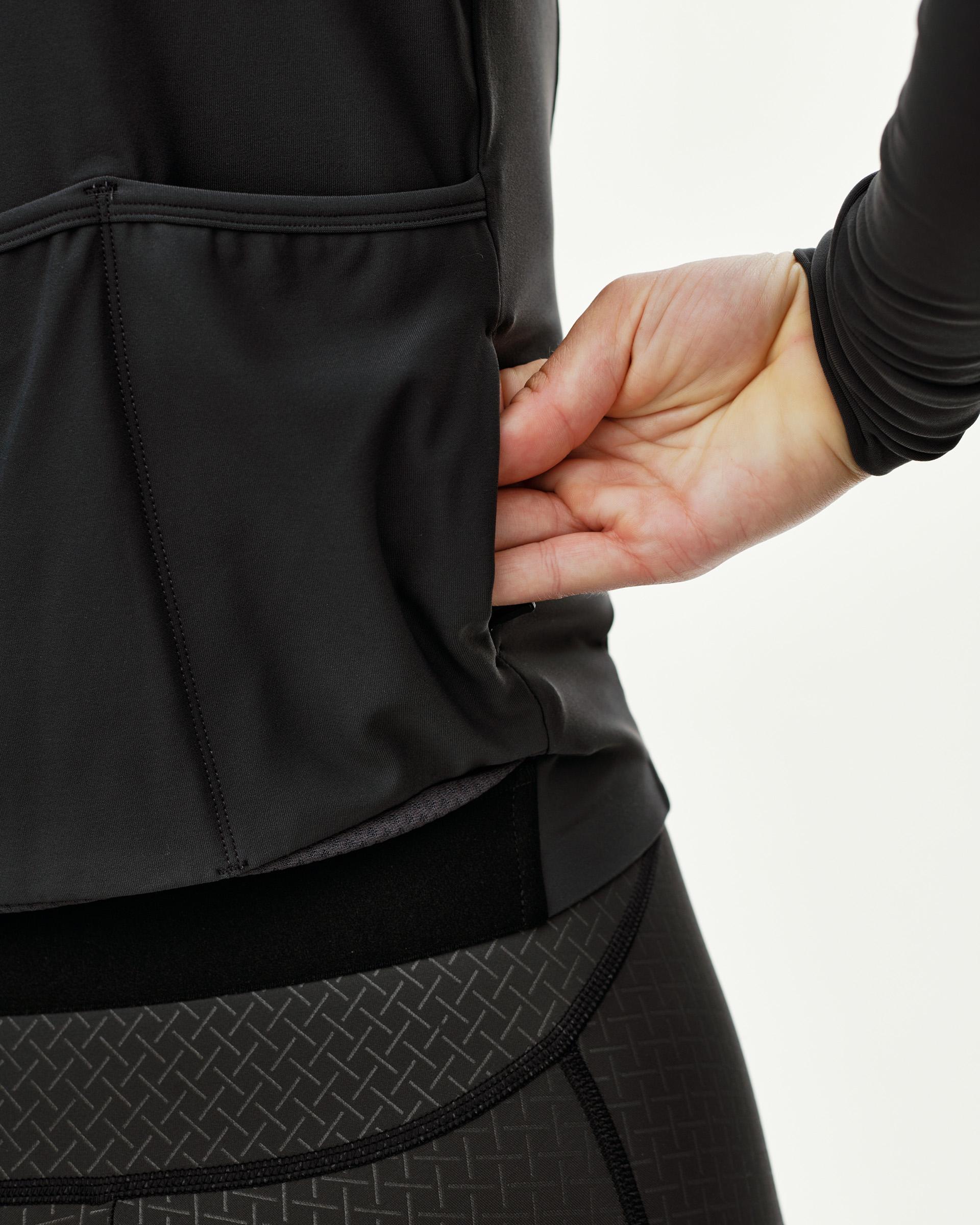 Dark Navy Mechanism women's long sleeve cycling jersey, side detail on model showing rear pocket opening