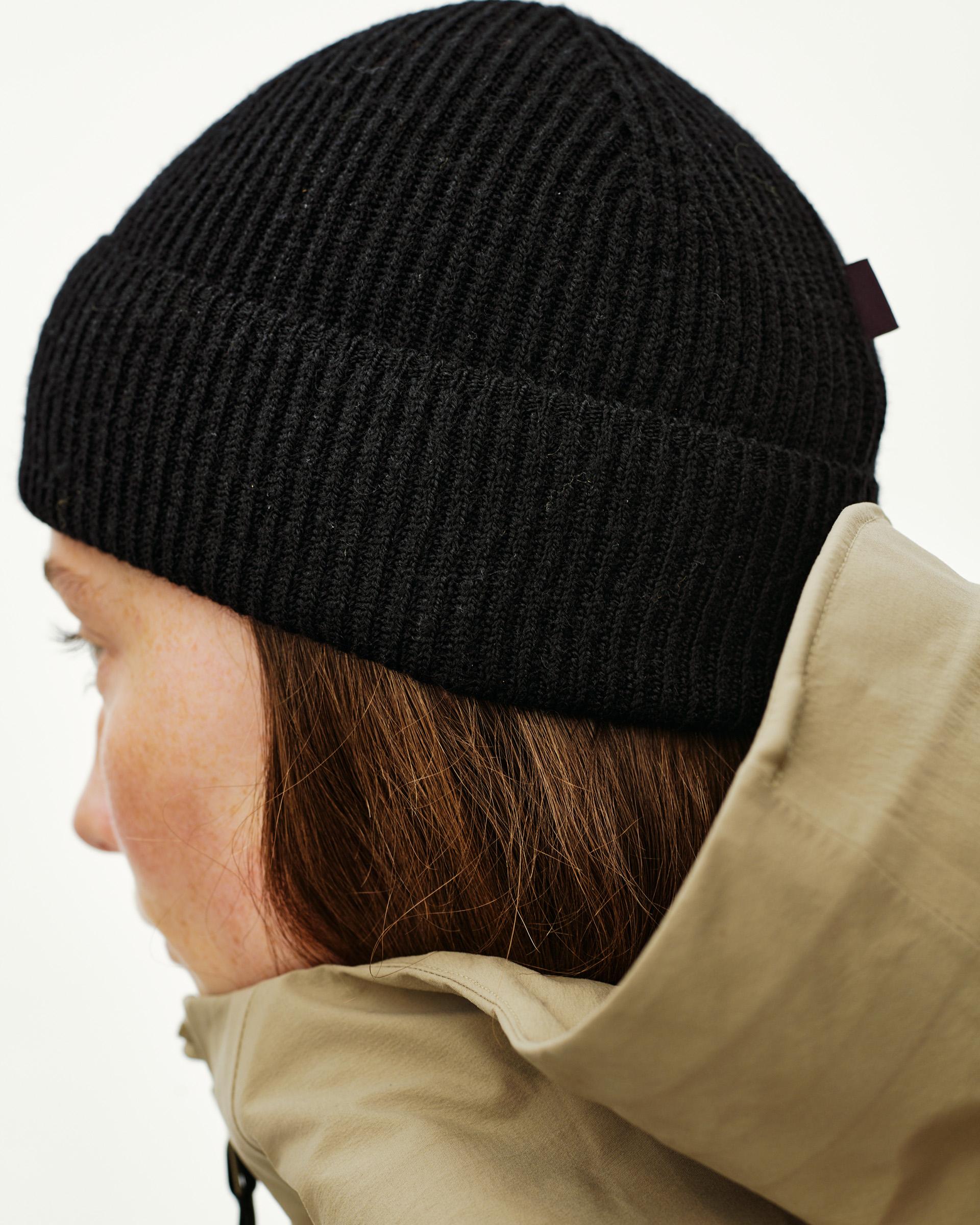 Black Off-Race Merino Knit Beanie on model, rear three-quarter view with ribbed cuff