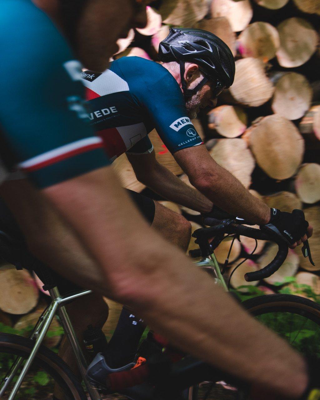 Model wearing blue cycling jersey in time trial position on bike