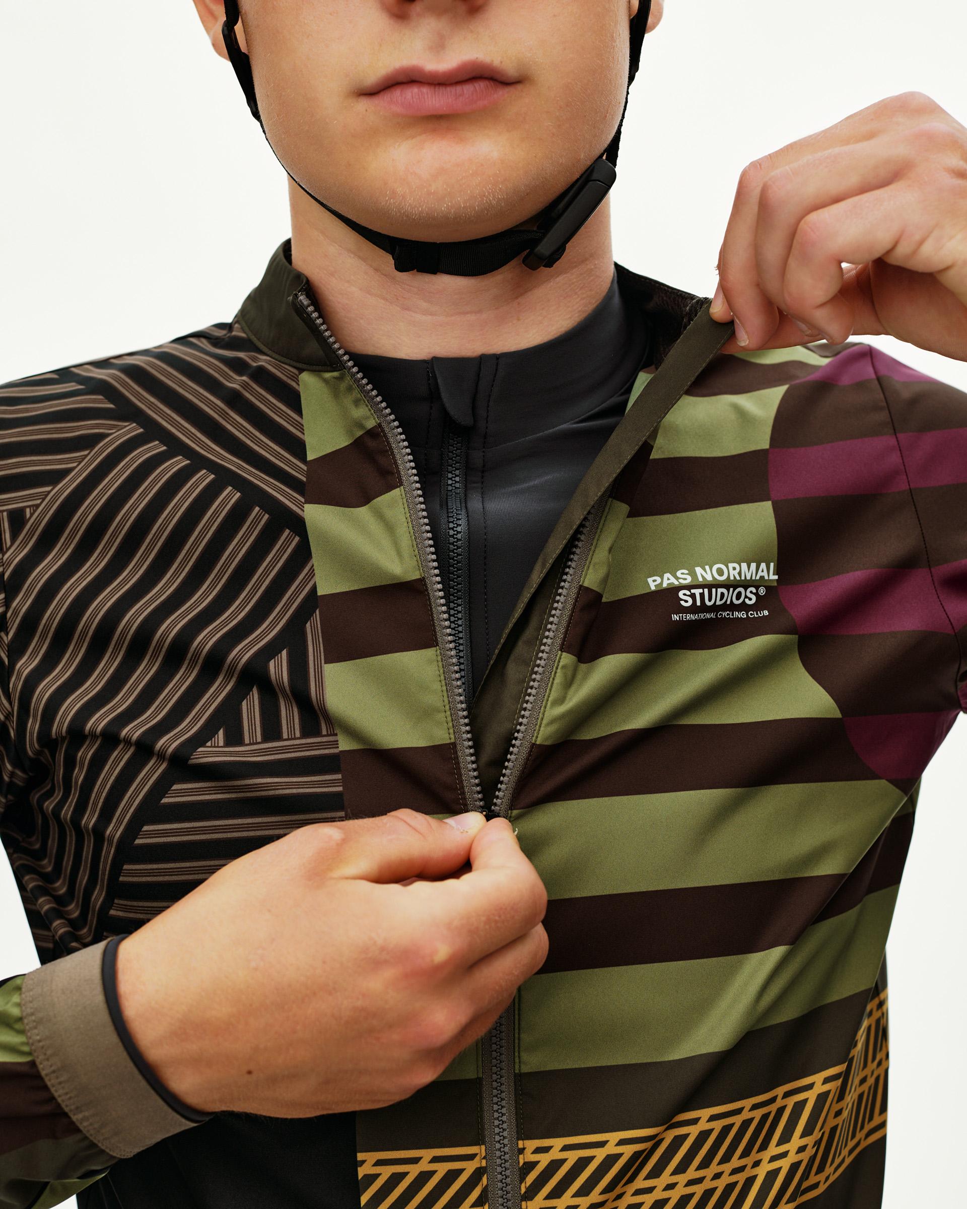 International Green Mechanism Stow Away cycling jacket, front detail on model with open zip and multicolor panel print