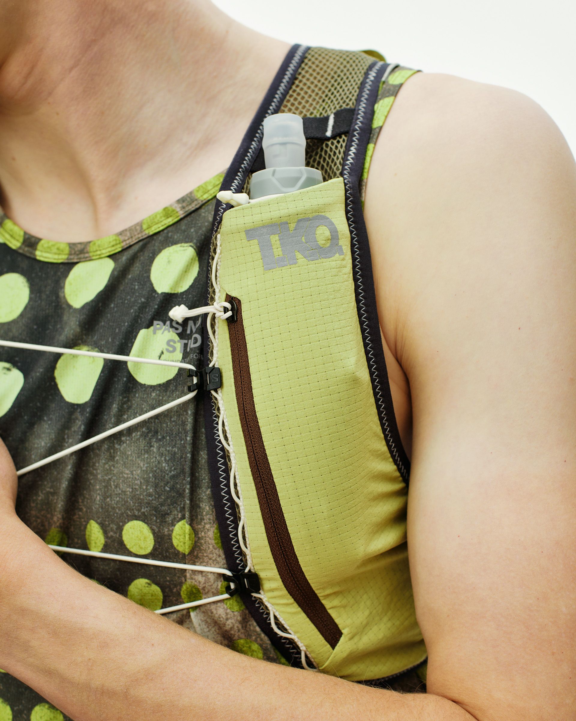 Green Salomon Race Skin 2 vest on model with water bottle in front pocket