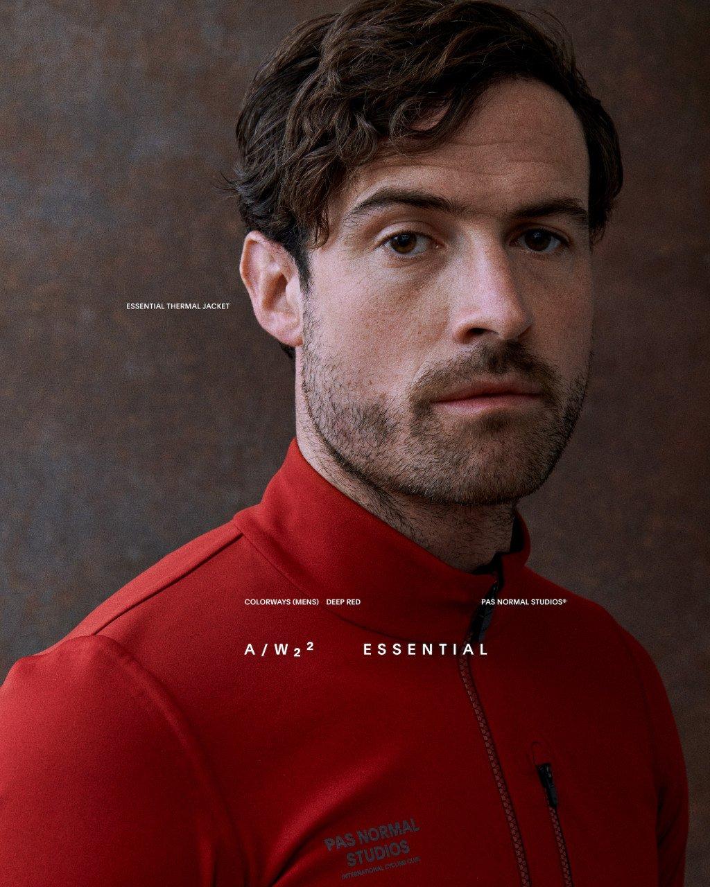 Model wearing Men's Essential Thermal Jacket in red with front zip and chest branding