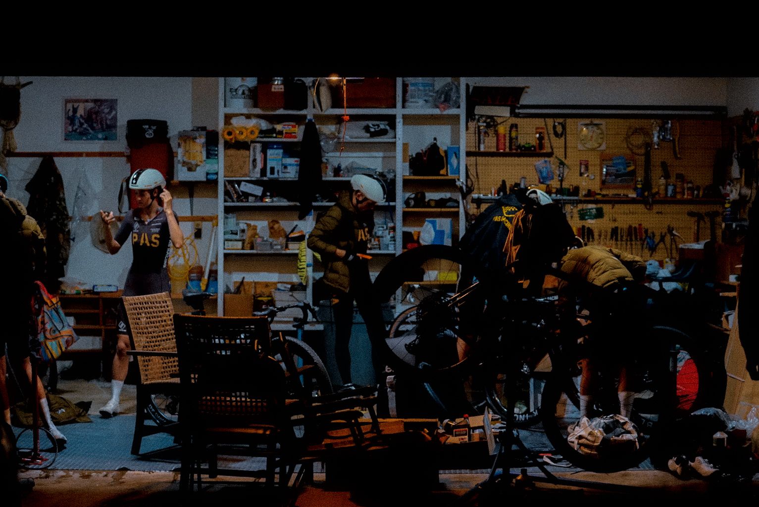 Cyclists preparing bikes and gear in workshop before Unbound Gravel race