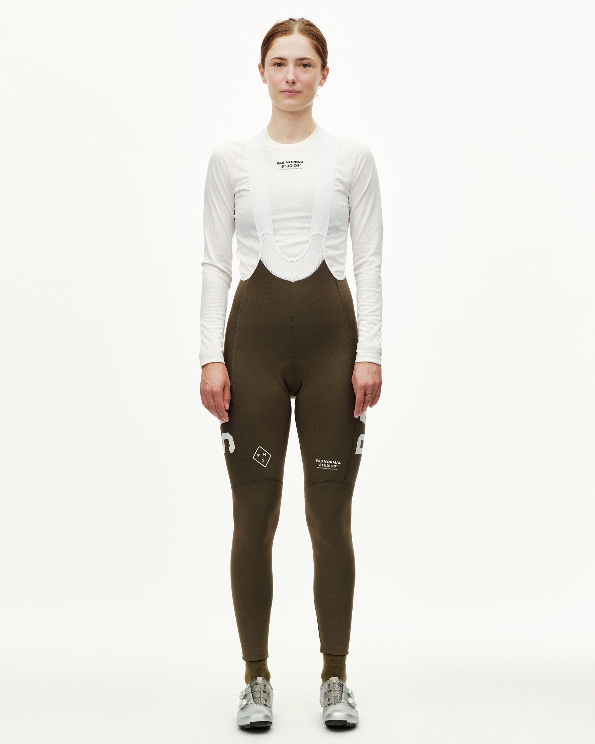 Dark Earth brown PAS Mechanism Thermal women's cycling long bibs on model, front view with white logo print
