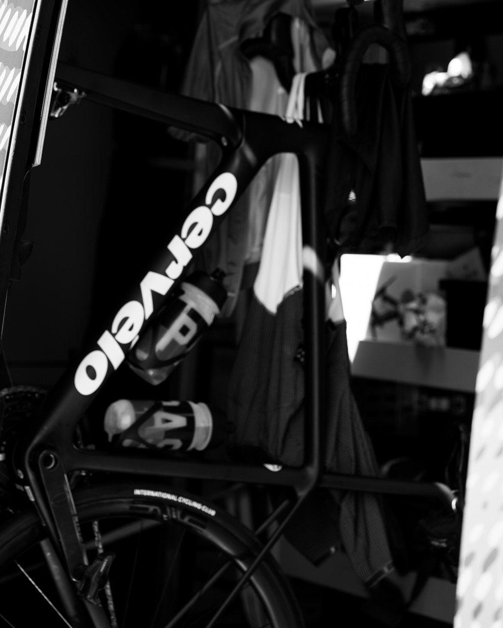 Black cycling bags with white branding loaded in car trunk, black and white photo
