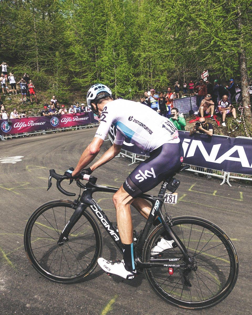 Professional cyclist in white time trial skinsuit with blue accents racing at Giro d'Italia