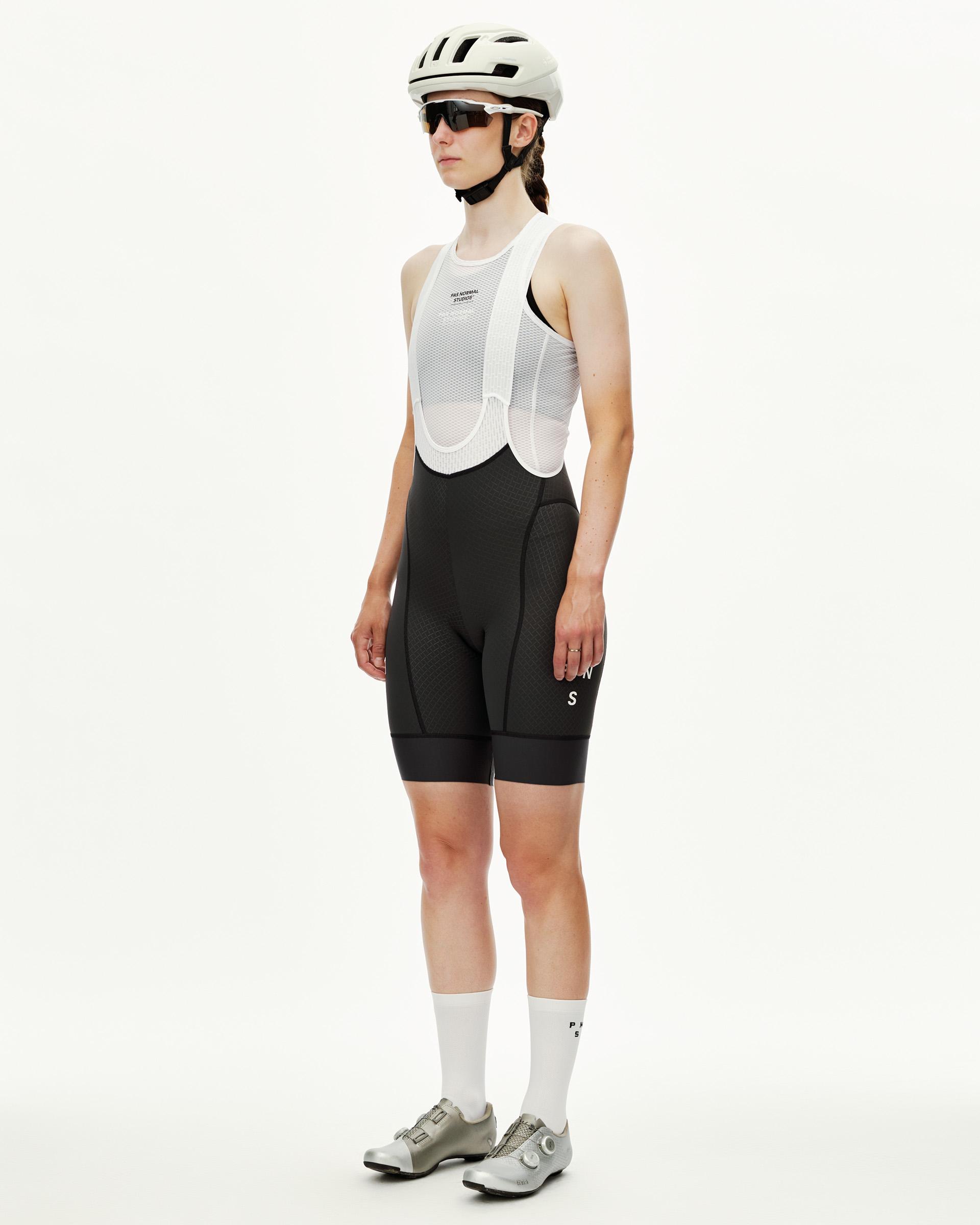 Dark Navy Mechanism women's cycling bib shorts on model, three-quarter front view with white mesh bib straps