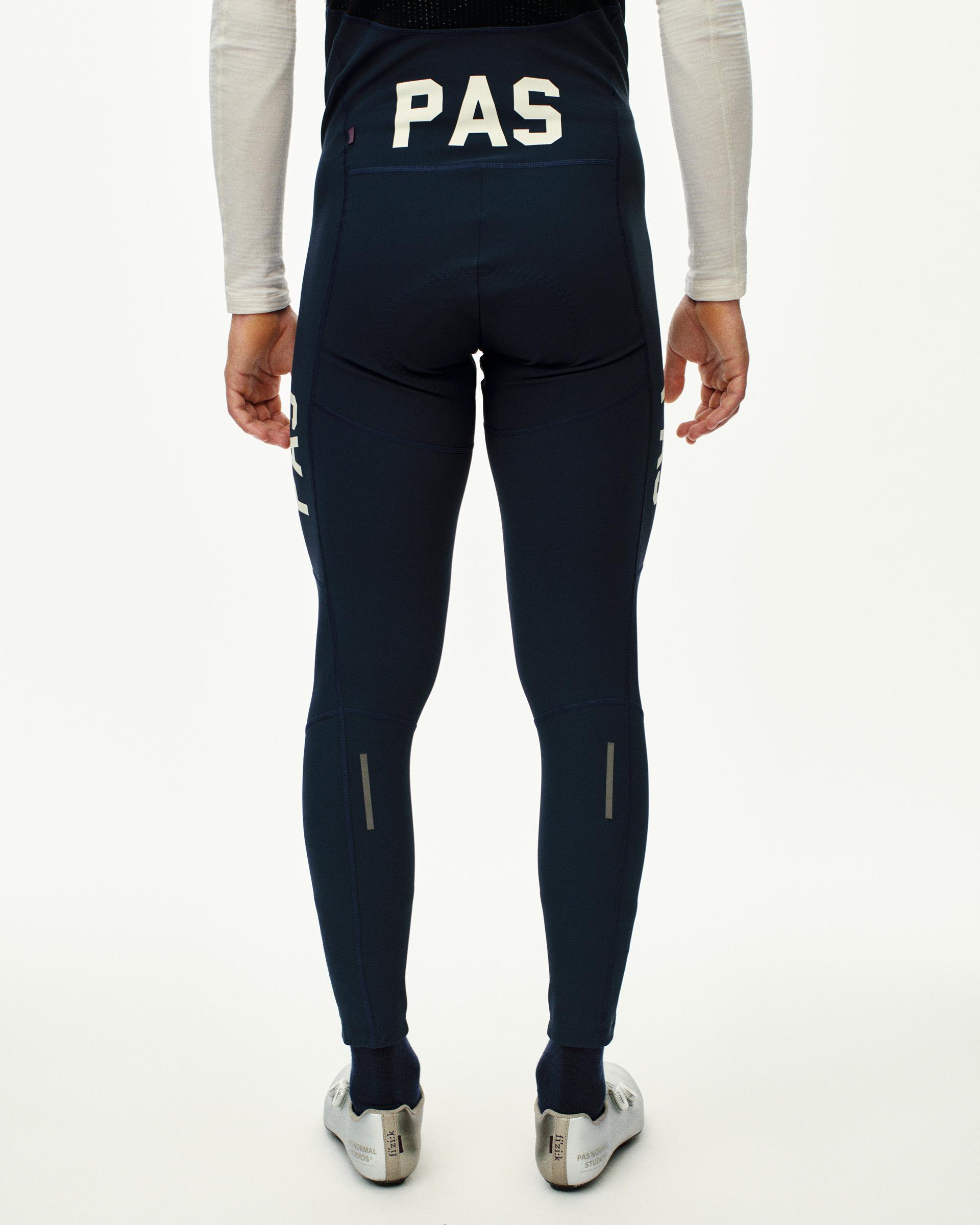Navy PAS Mechanism Deep Winter long bibs on model, rear view with white PAS logo and reflective ankle strips