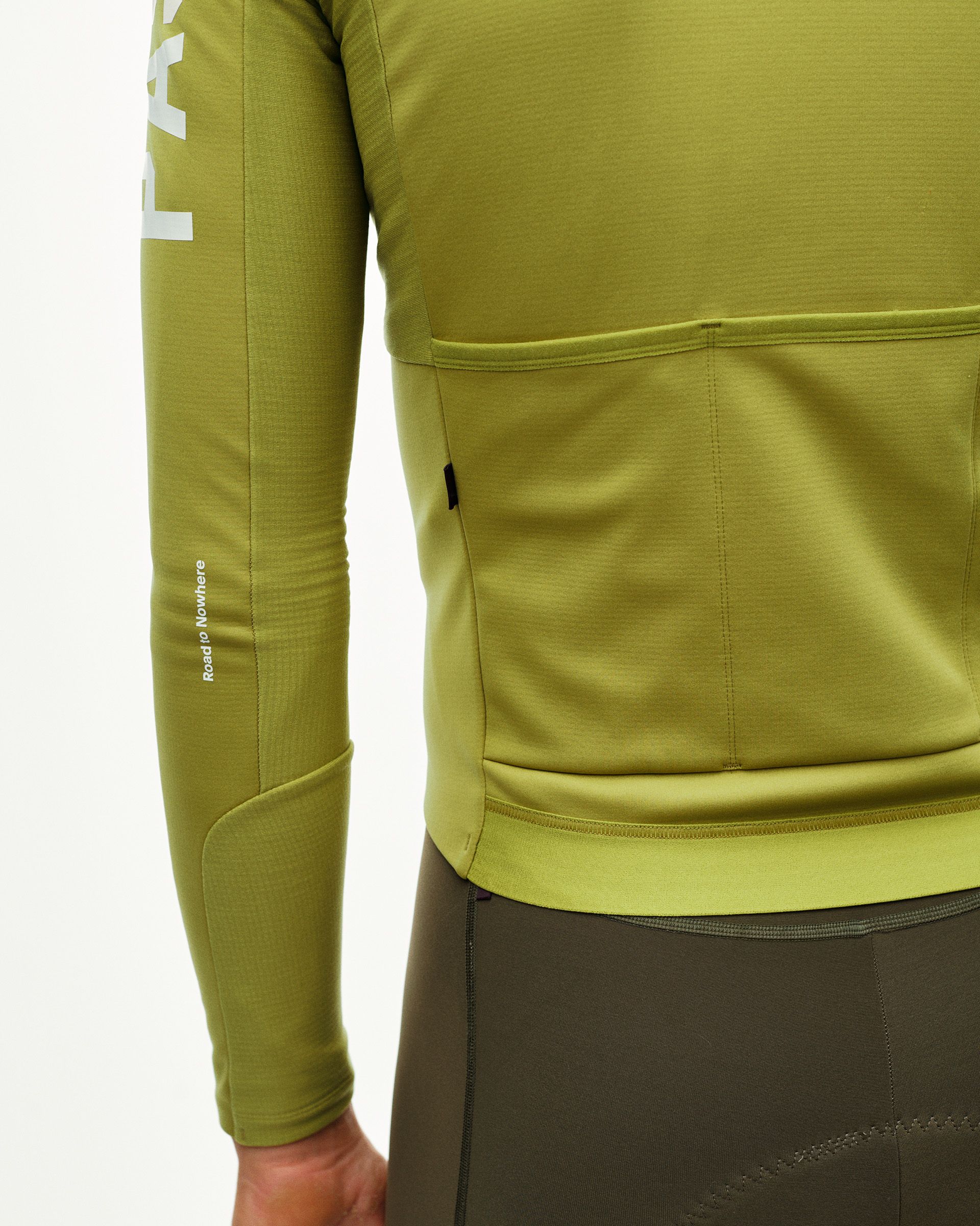 Dark Lime PAS Mechanism Thermal Long Sleeve cycling jersey, rear detail on model with back pockets and contrast hem band
