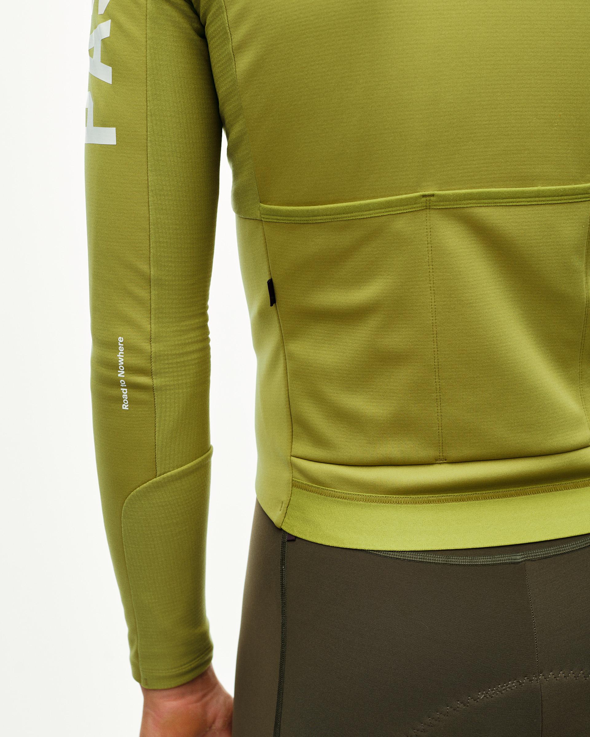 Dark Lime PAS Mechanism Thermal Long Sleeve cycling jersey, rear detail on model with back pockets and contrast hem band