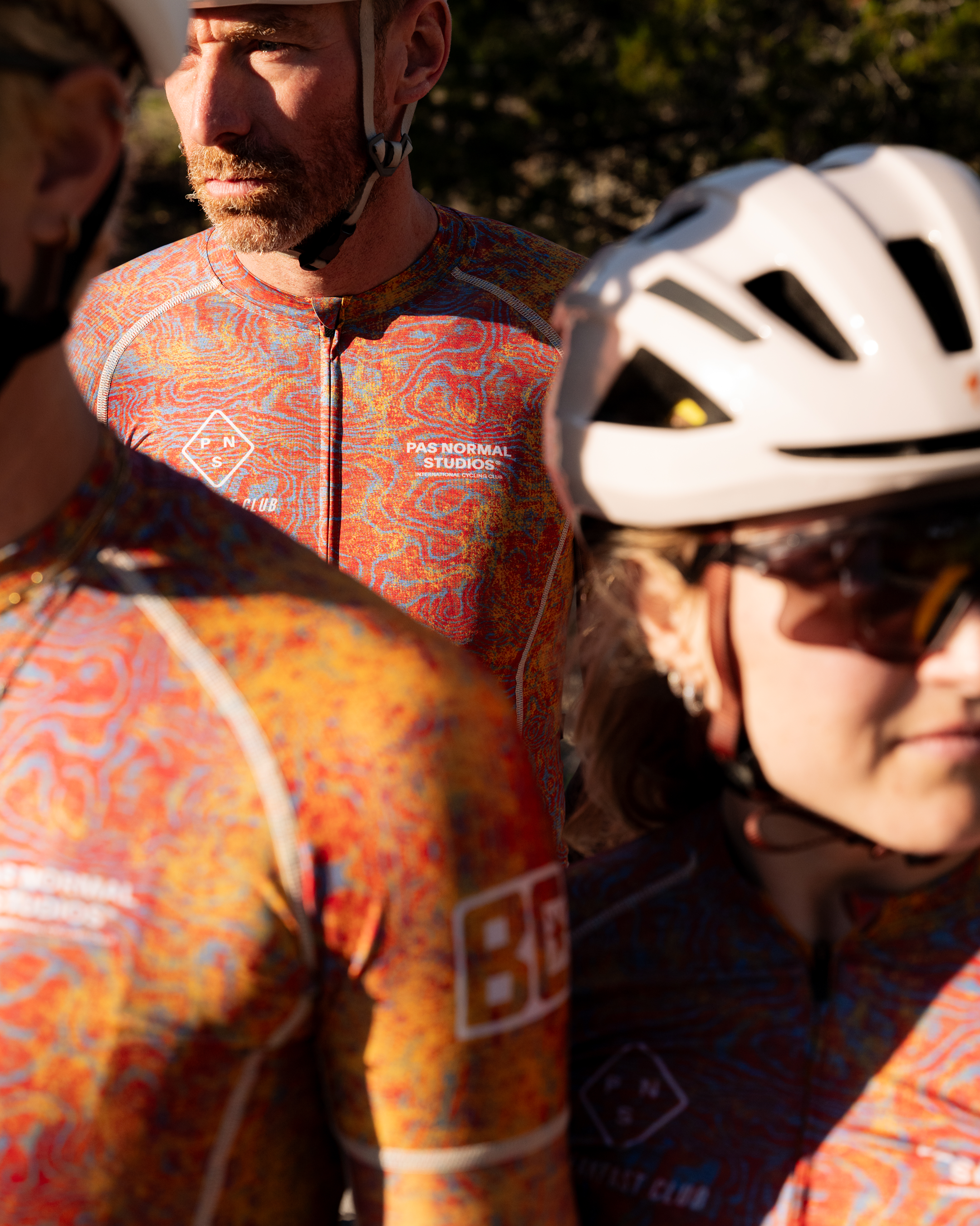 Model wearing Breakfast Club jersey and shorts in orange swirl pattern with white helmet