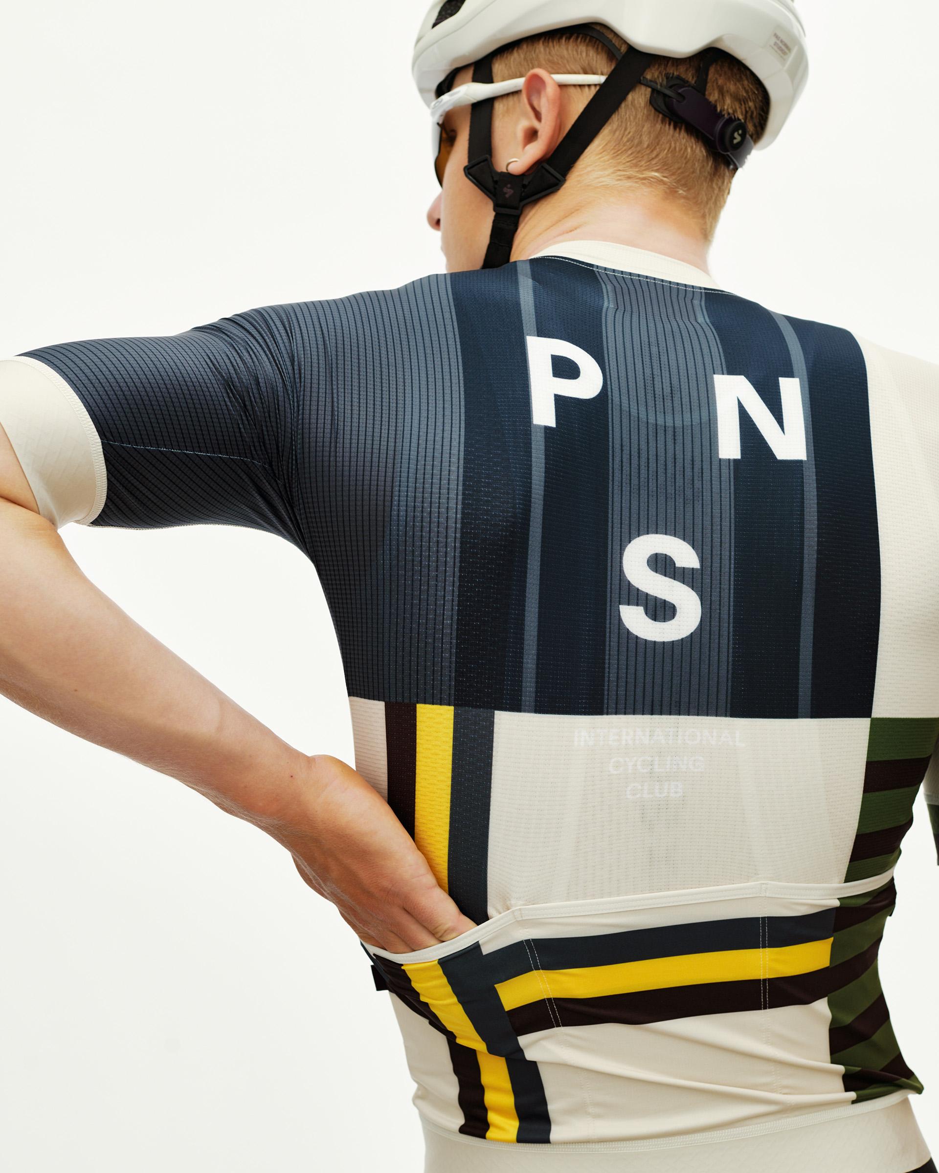 International Sand Mechanism cycling jersey on model, rear view with bold multicolor block stripe print and large back logo
