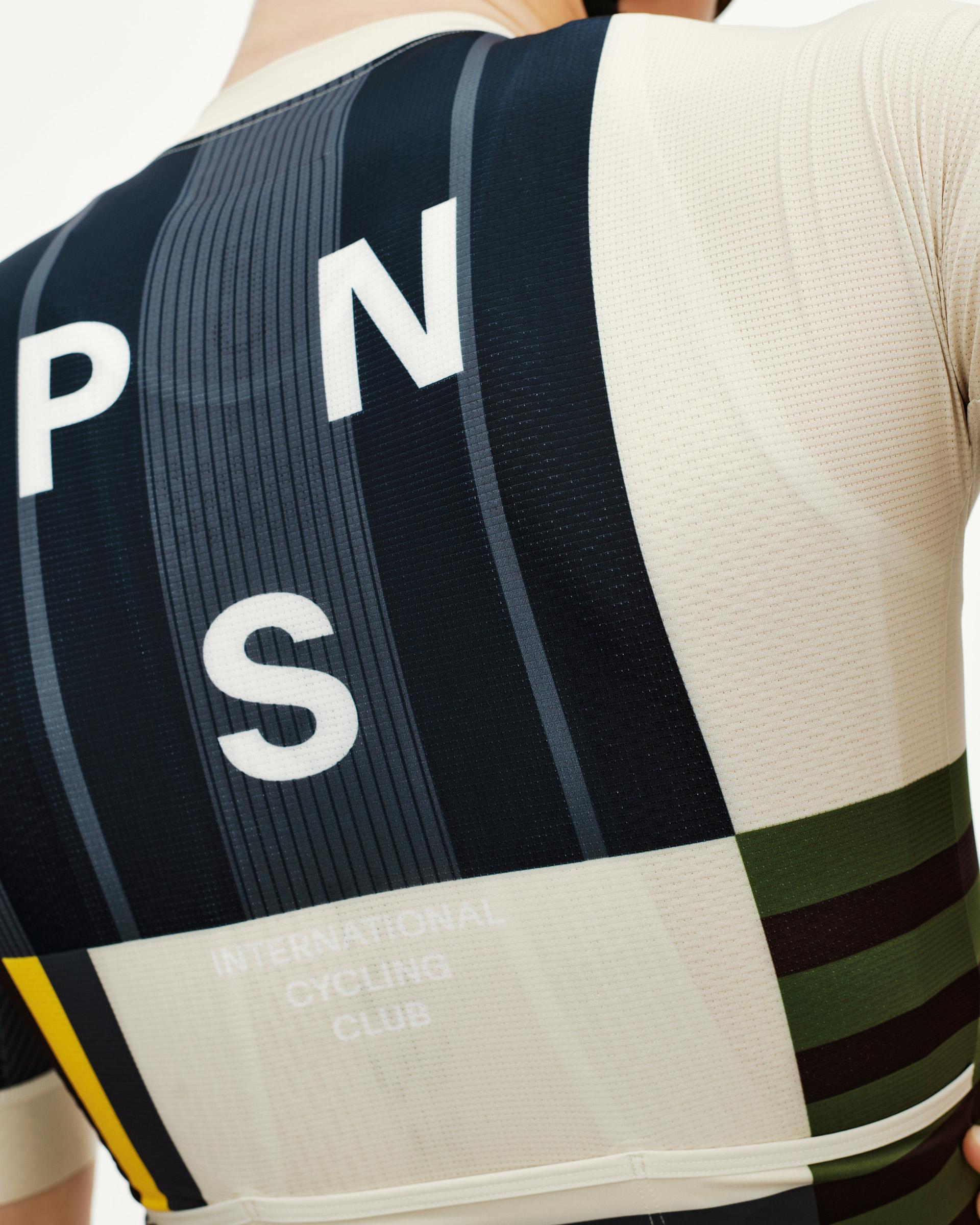 International Sand Mechanism cycling jersey, rear detail on model with navy and cream colour-block panel and large PNS