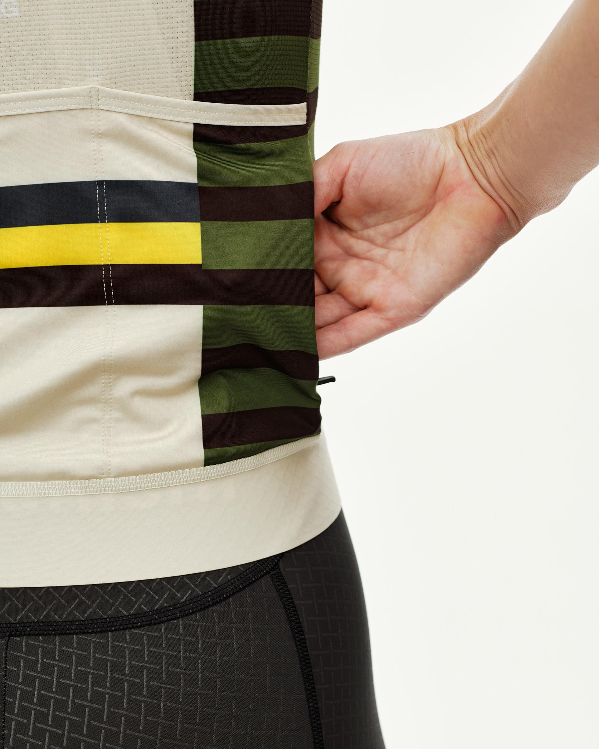 International Sand Mechanism women's cycling jersey, side detail on model with multicolor block stripe print