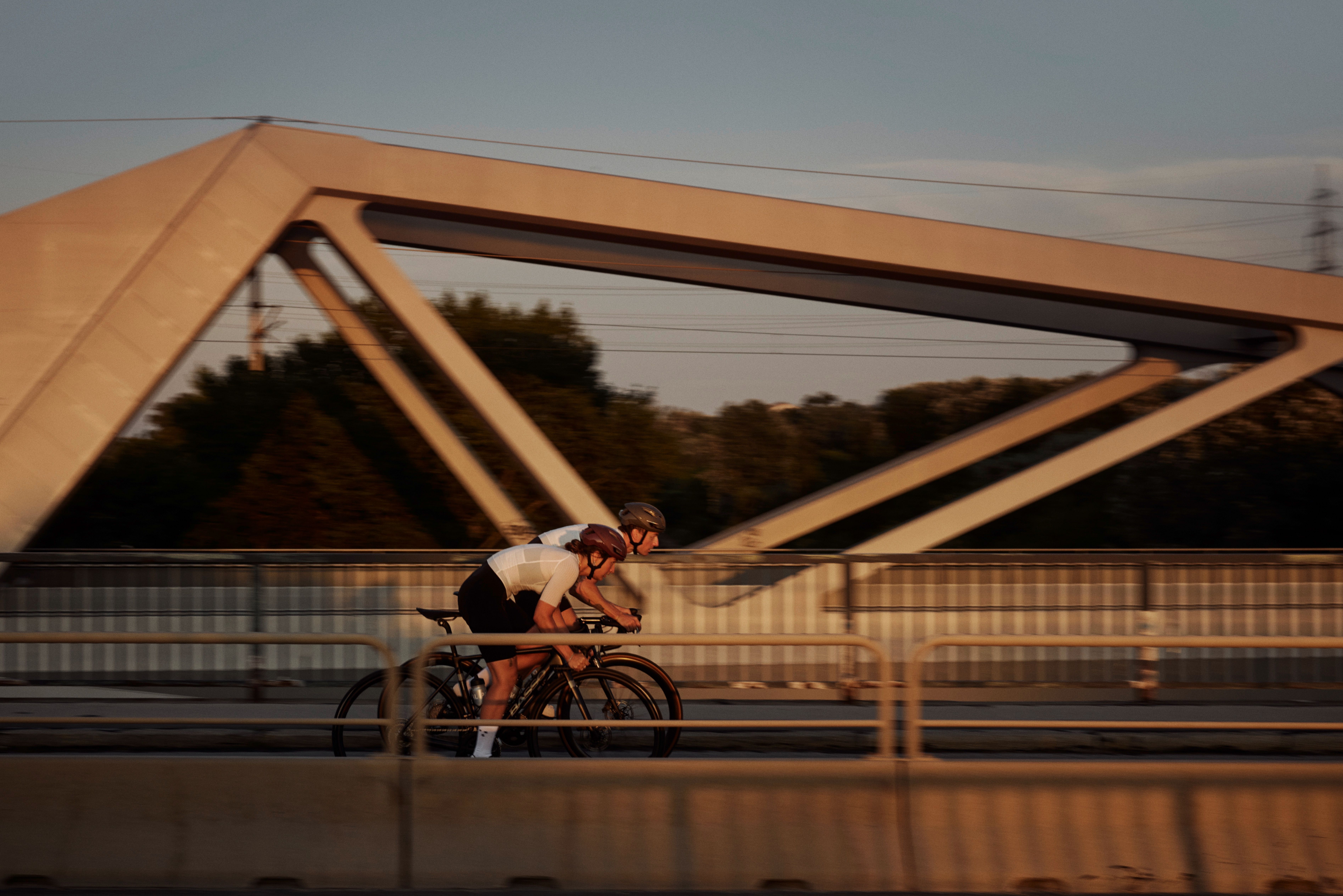Off White Mechanism Pro cycling jersey on cyclist in aerodynamic position during golden hour