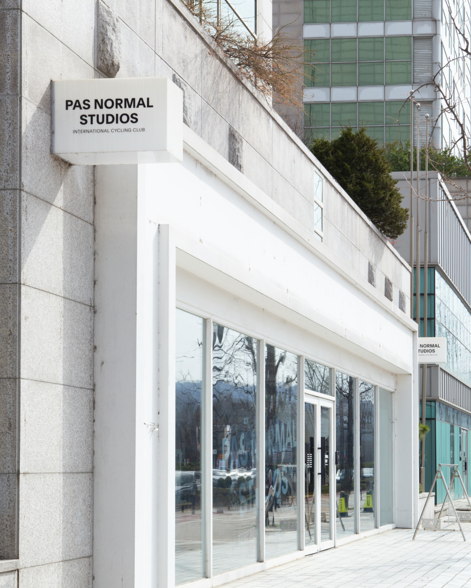 Brand storefront exterior with white signage and large glass windows in Seoul
