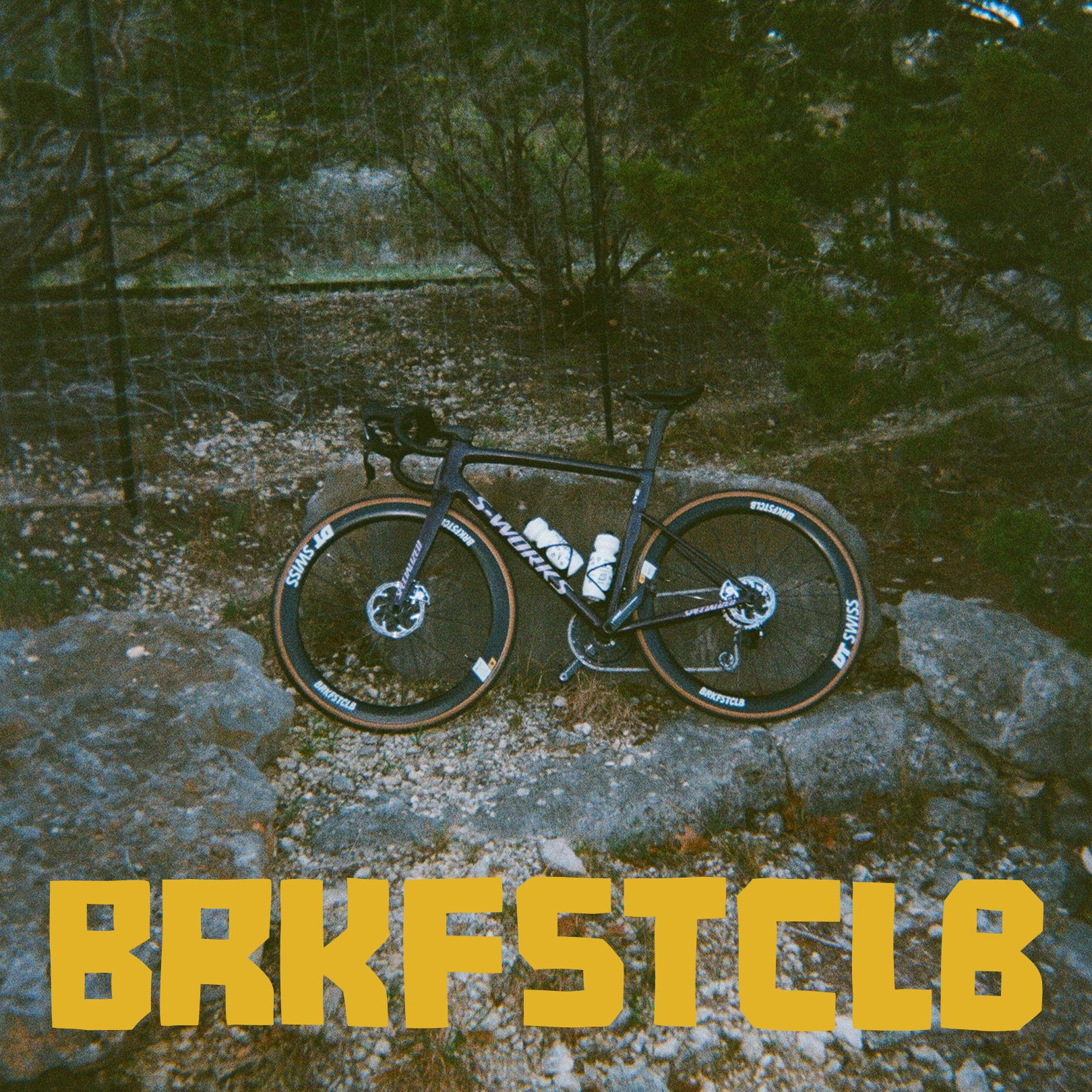 Black racing bicycle in natural outdoor setting with rocks and trees