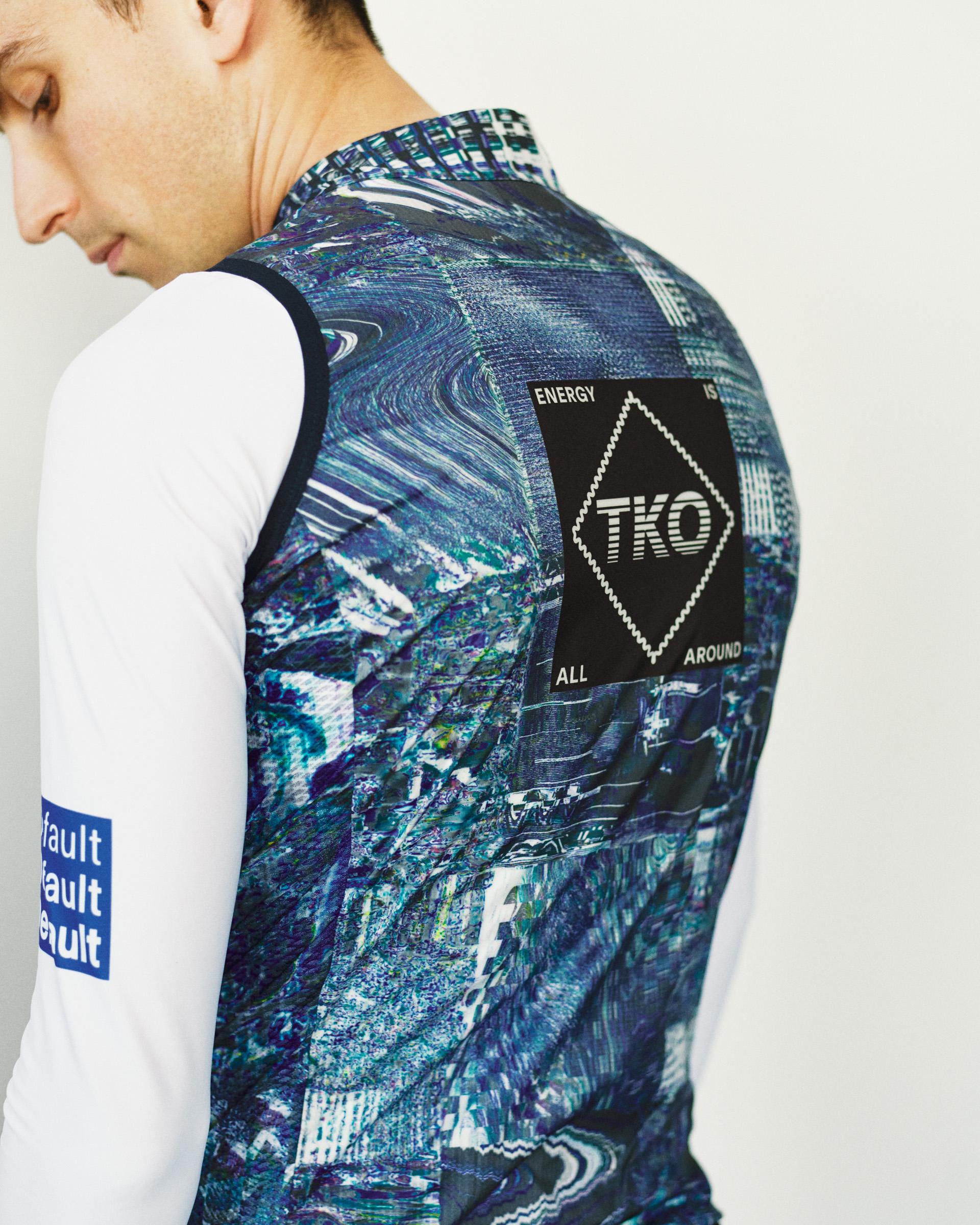 Human Error Blue T.K.O. Mechanism Stow Away cycling gilet, rear view on model with abstract print and TKO back patch
