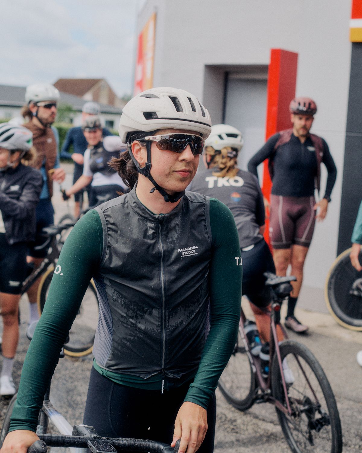 Female cyclist wearing green long-sleeve jersey with black vest at cycling event