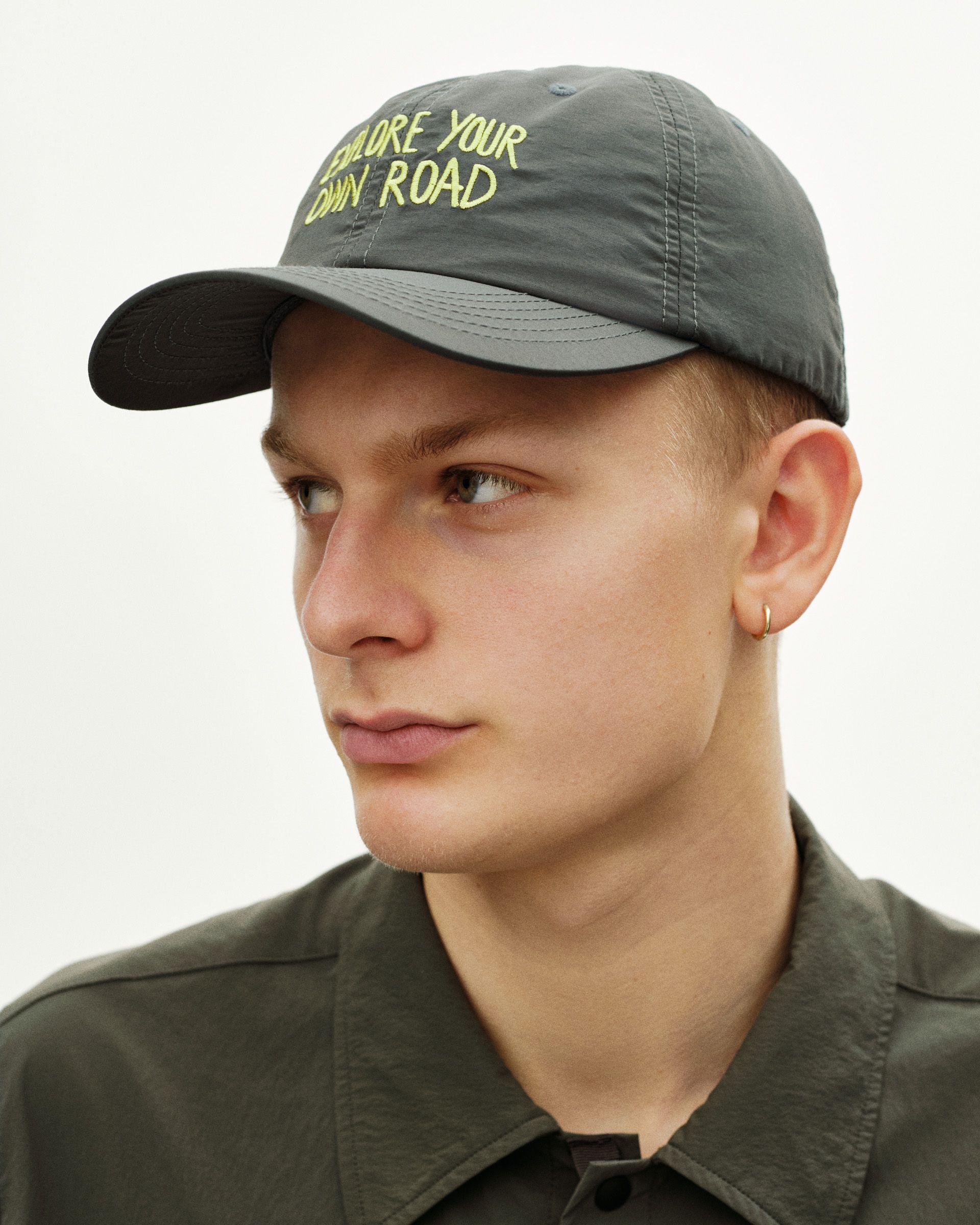 Dark Grey Off-Race cap on model with yellow embroidered text
