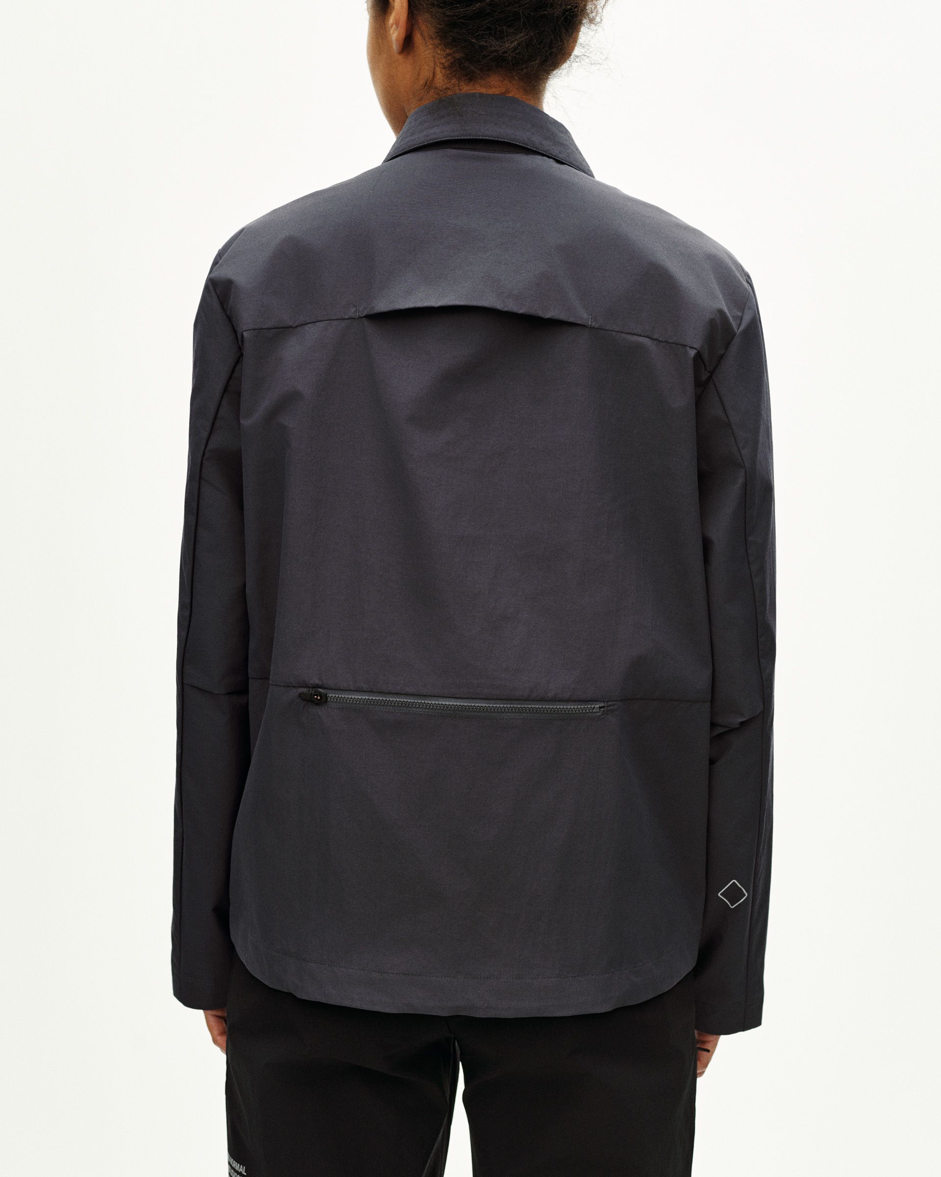 Grey Off-Race Utility jacket, rear view on model with zip pocket and storm flap