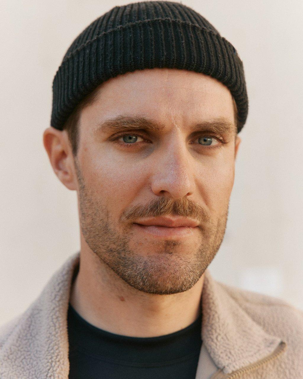 Model wearing dark green ribbed knit beanie