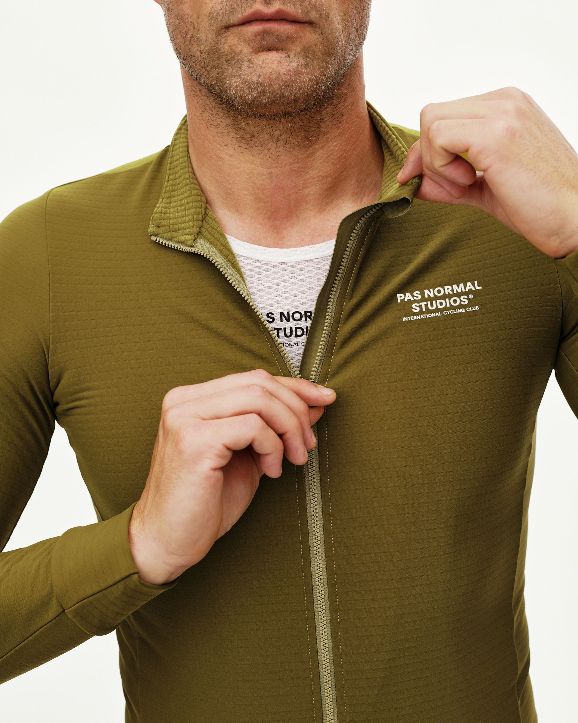 Khaki Green Essential long sleeve cycling jersey, front detail on model with full zip open and white chest print