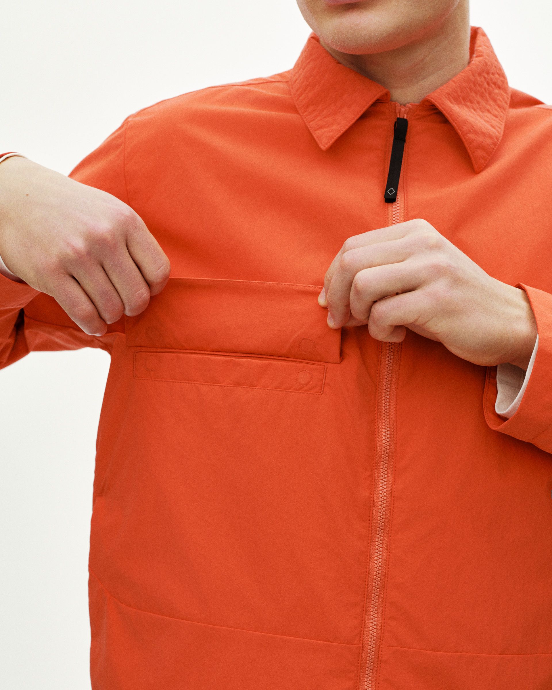 Orange Off-Race Utility jacket on model showing chest pocket and full front zip
