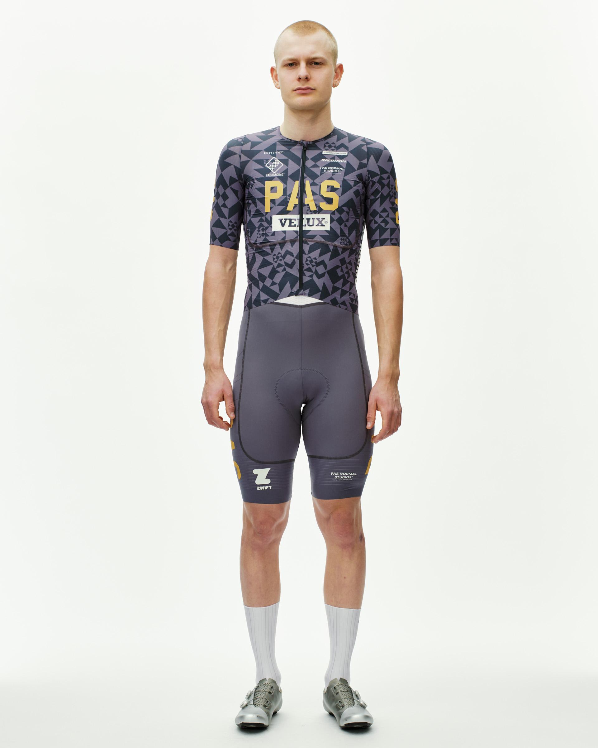 Origami Grey PAS Mechanism Pro cycling jersey on model, front view with geometric print and gold chest logo